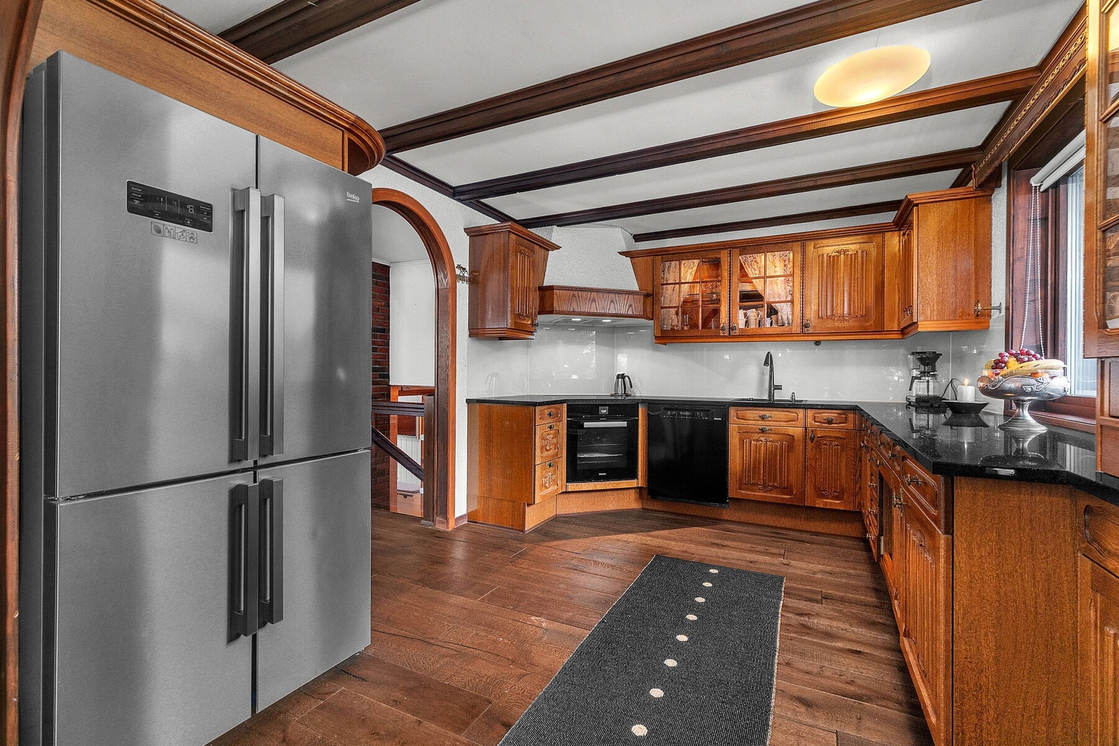 Romslig kjøkken med hvitevarer og benkeplate av nyere dato. Galleribilde