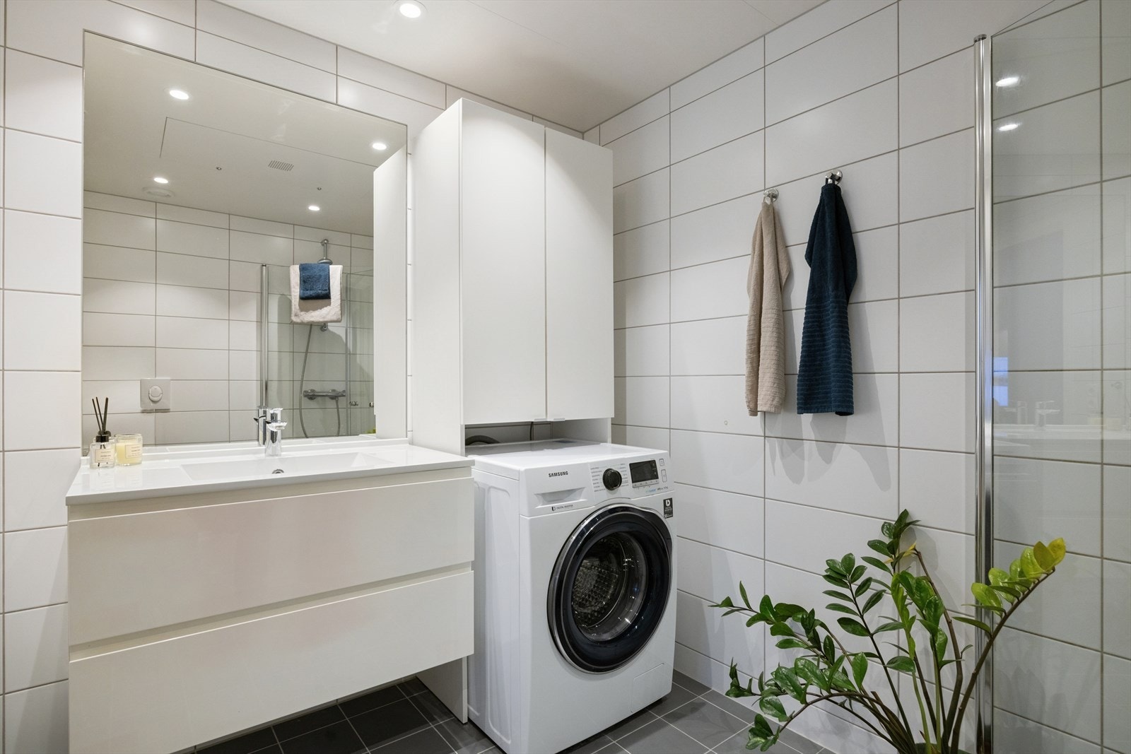 Badet har elektrisk gulvvarme for økt komfort og praktisk opplegg for vaskemaskin. Galleribilde