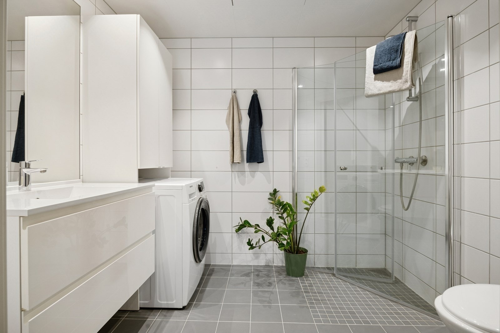 Moderne, flislagt bad fra byggeåret med dusjhjørne i glass og vegghengt toalett. Galleribilde