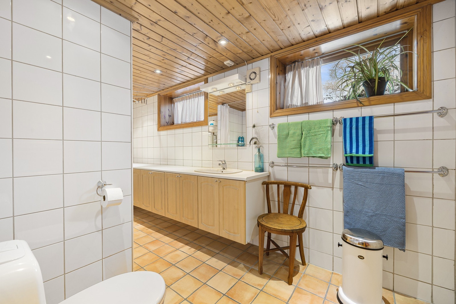 I kjelleretasjen er det et stort, flislagt familiebad innredet med dusjnisje, toalett og opplegg for vaskemaskin. Galleribilde