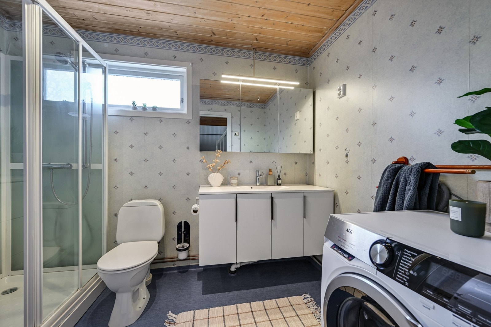 Bad med vinylbelegg på gulvet, baderomstapet på veggene og panel i himling. Galleribilde