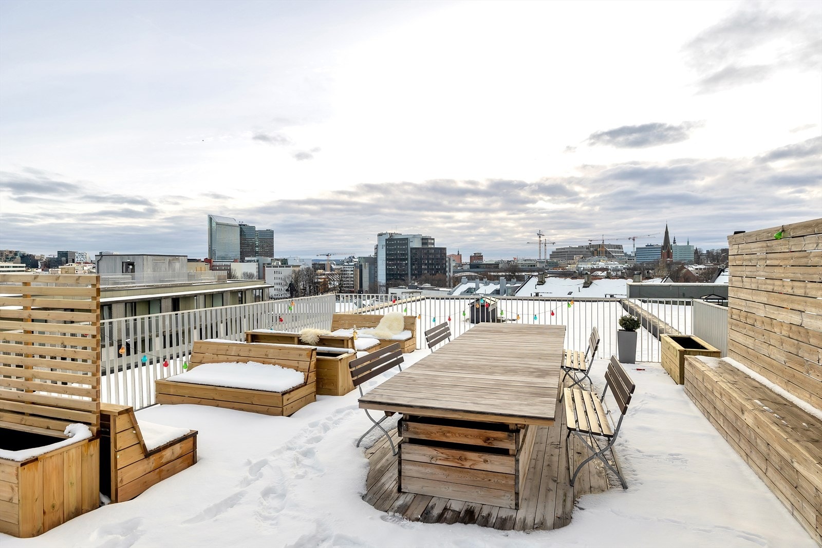 Takterrassen har trebenker og bord med utsikt over byen. Galleribilde