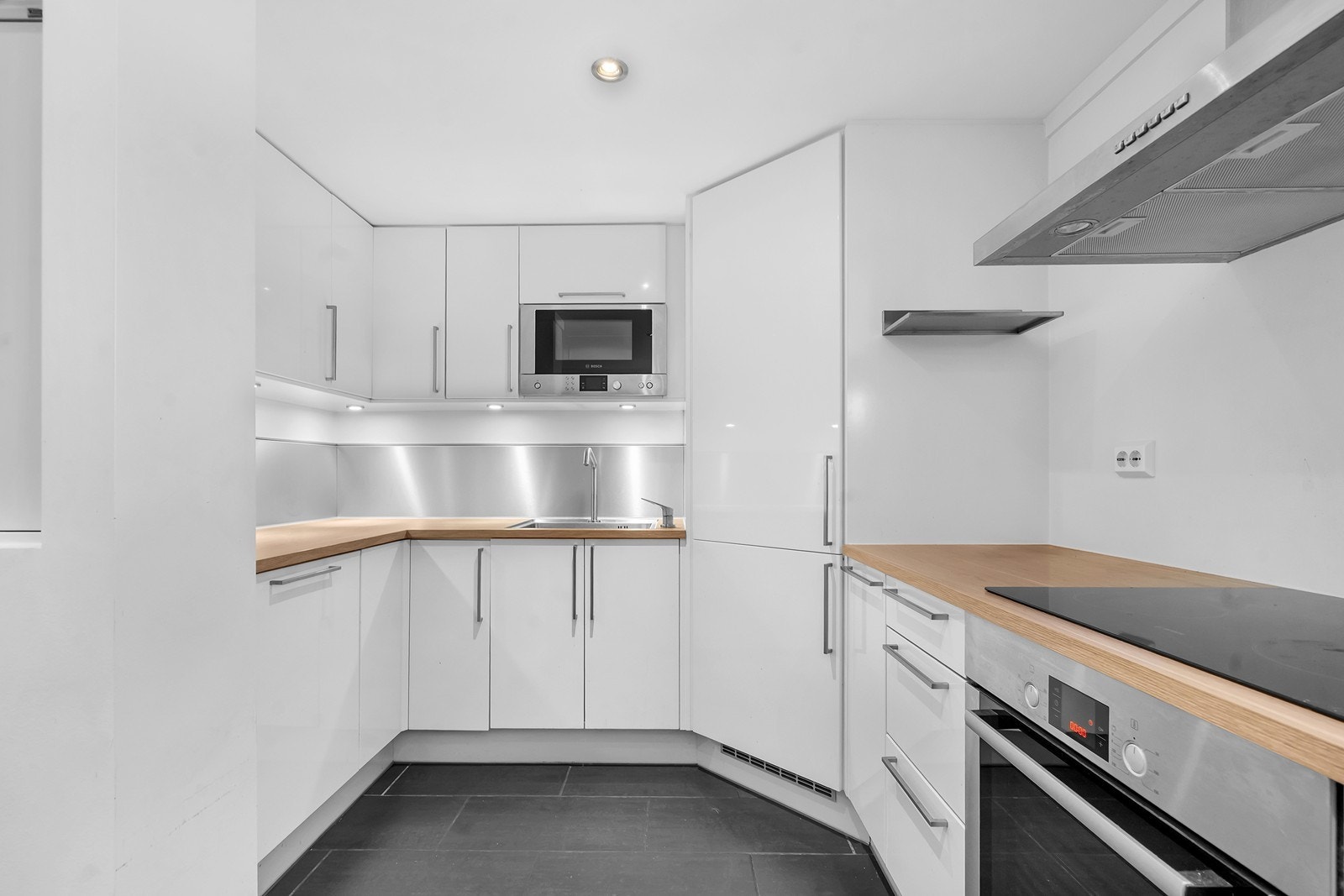 Kjøkken med integrerte hvitevarer og mye skapplass. Galleribilde