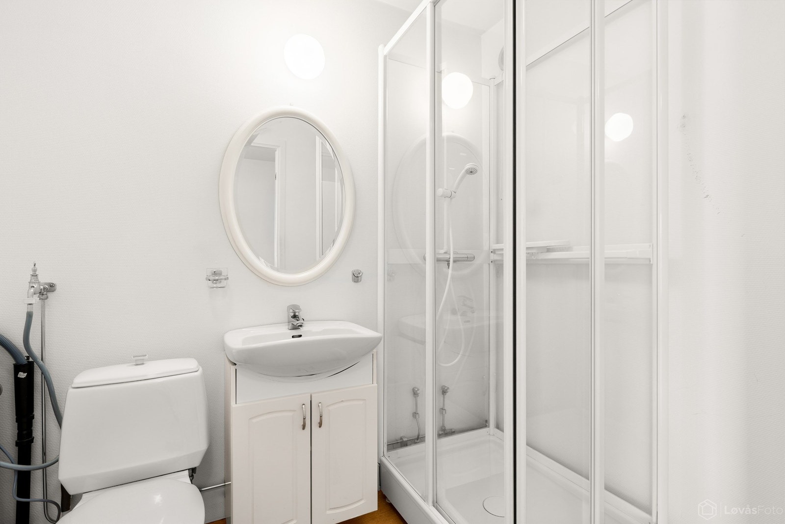 Badet er utstyrt med servantinnredning, speil med belysning, dusjkabinett og toalett. Galleribilde