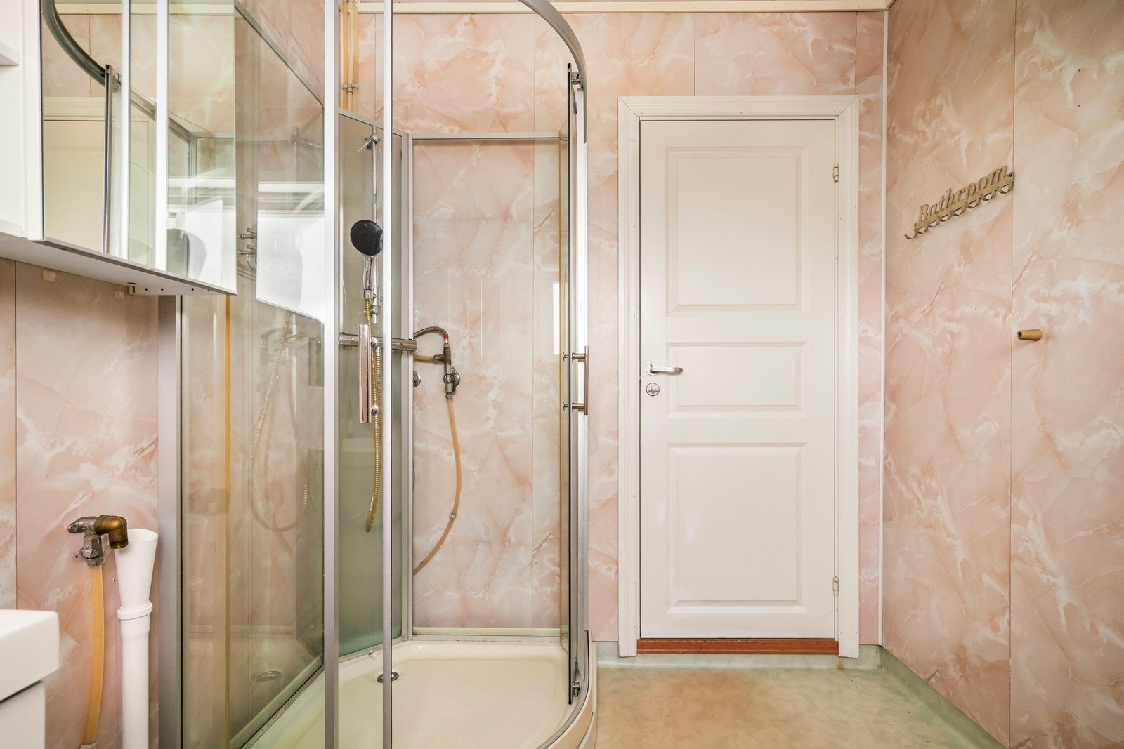 Badet inneholder toalett, helstøpt servant, skuffer under servant med slette fronter, dusjkabinett og opplegg for vaskemaskin. Galleribilde