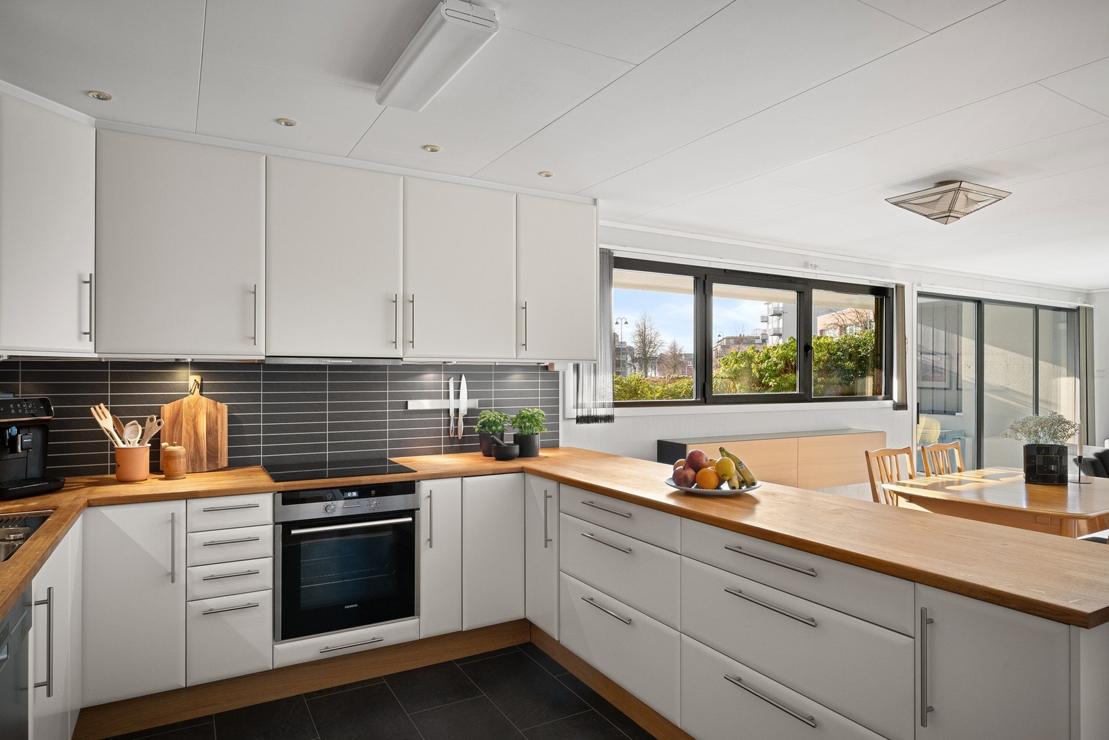 Pent og innholdsrikt kjøkken med integrerte hvitevarer og god oppbevaringsplass Galleribilde