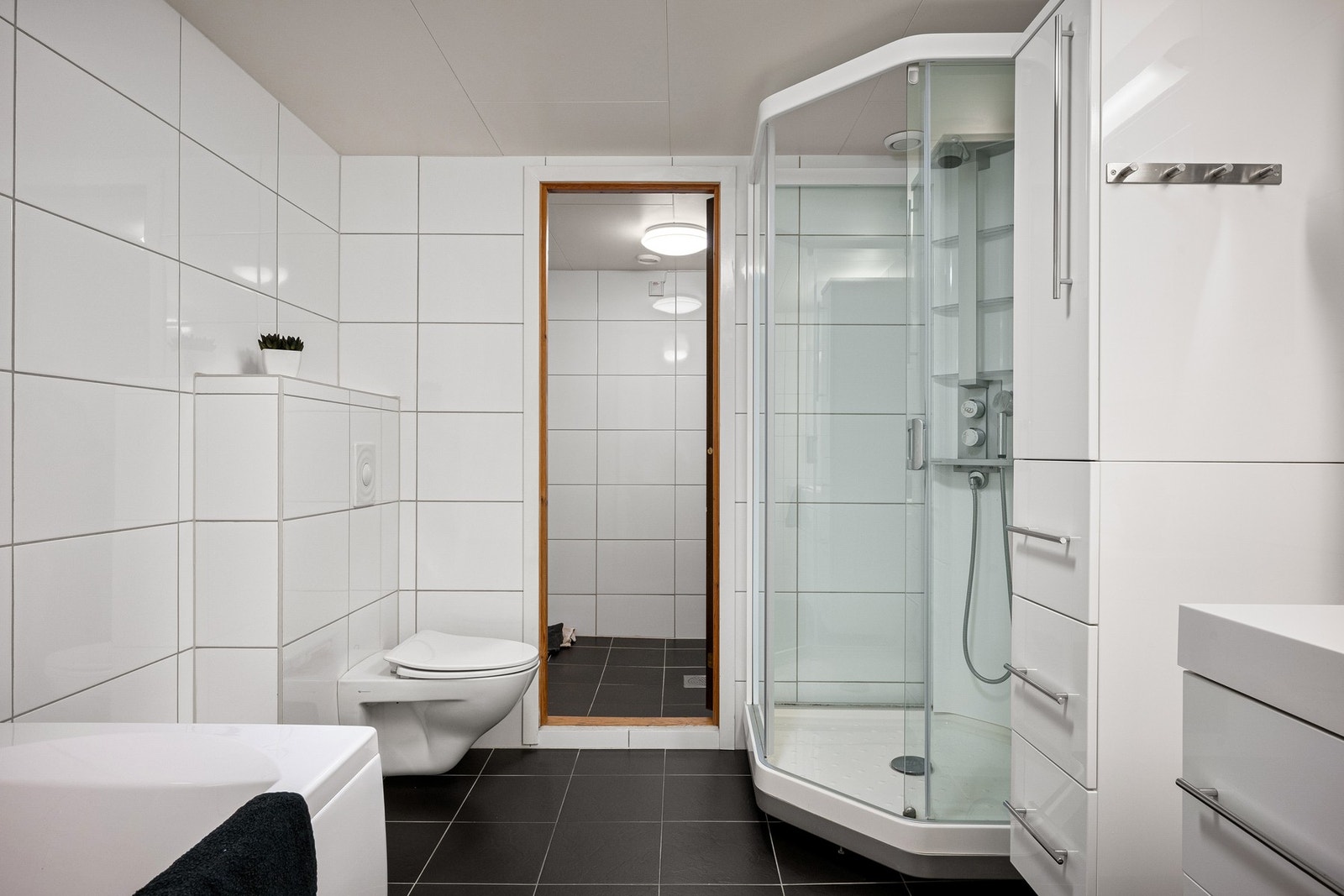 Badet er innredet med både badekar og dusjkabinett, og har direkte tilgang til vaskerom Galleribilde