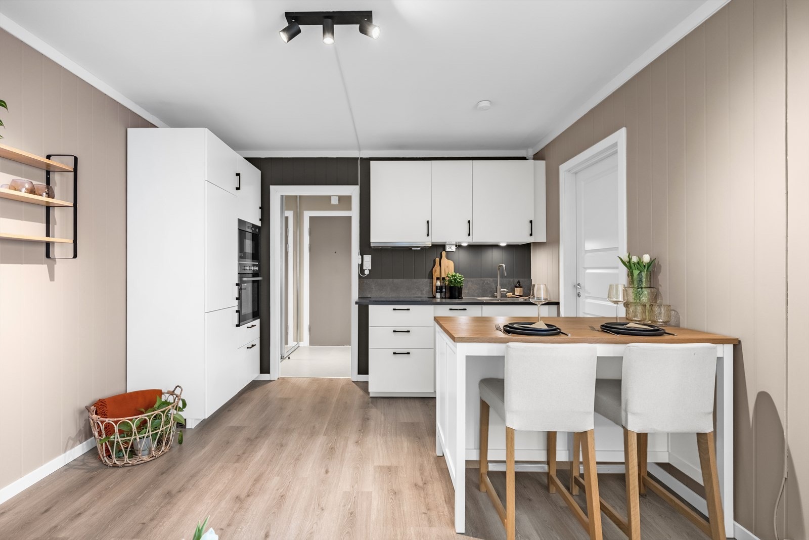 Stilrent kjøkken med glatte fronter og heltre benkeplate på halvøy - ekstra arbeidsplass og naturlig avgrensning mot stue. Galleribilde