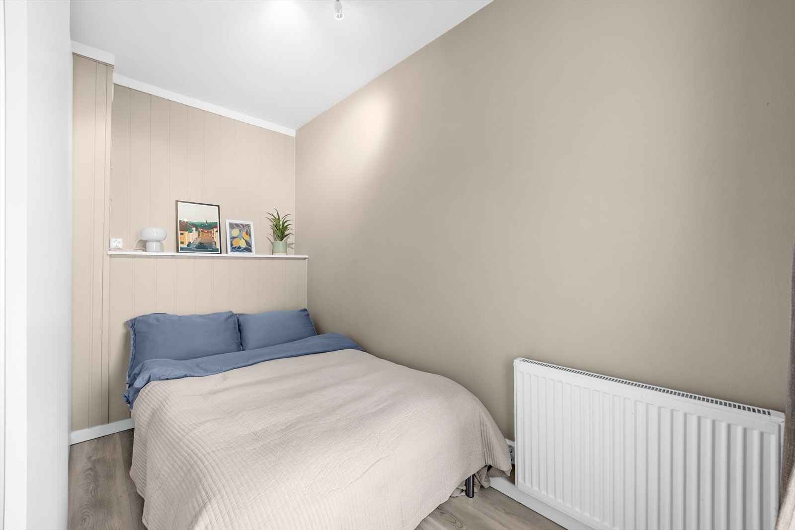 Rommet fremstår lyst og innbydende, og nisjen over sengen gir en praktisk og dekorativ oppbevaringsløsning. Galleribilde