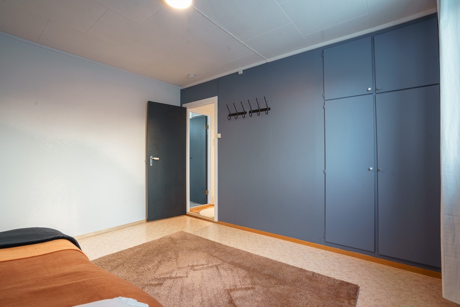 Lyst og romslig soverom med innbygde skap og praktisk oppheng. Perfekt for en stilren og funksjonell bolig. Galleribilde