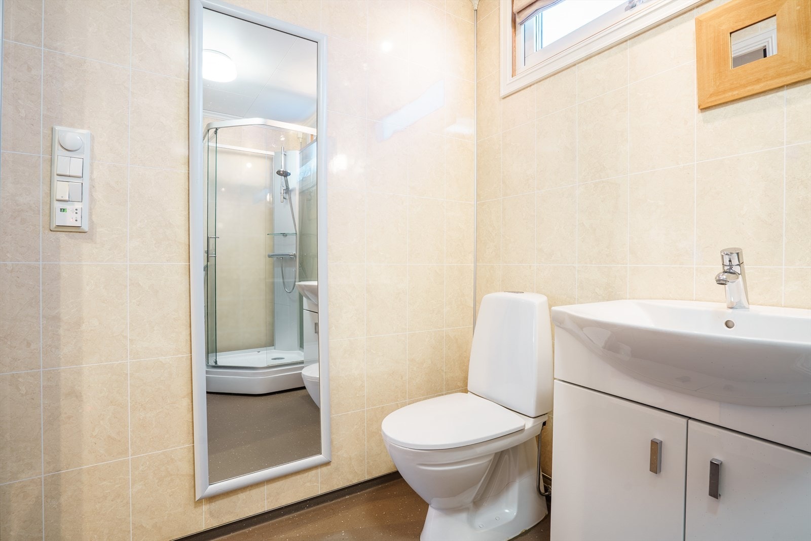 Lyst og moderne bad med dusjkabinett og praktisk innredning. Perfekt for deg som ønsker en stilren og funksjonell løsning. Galleribilde