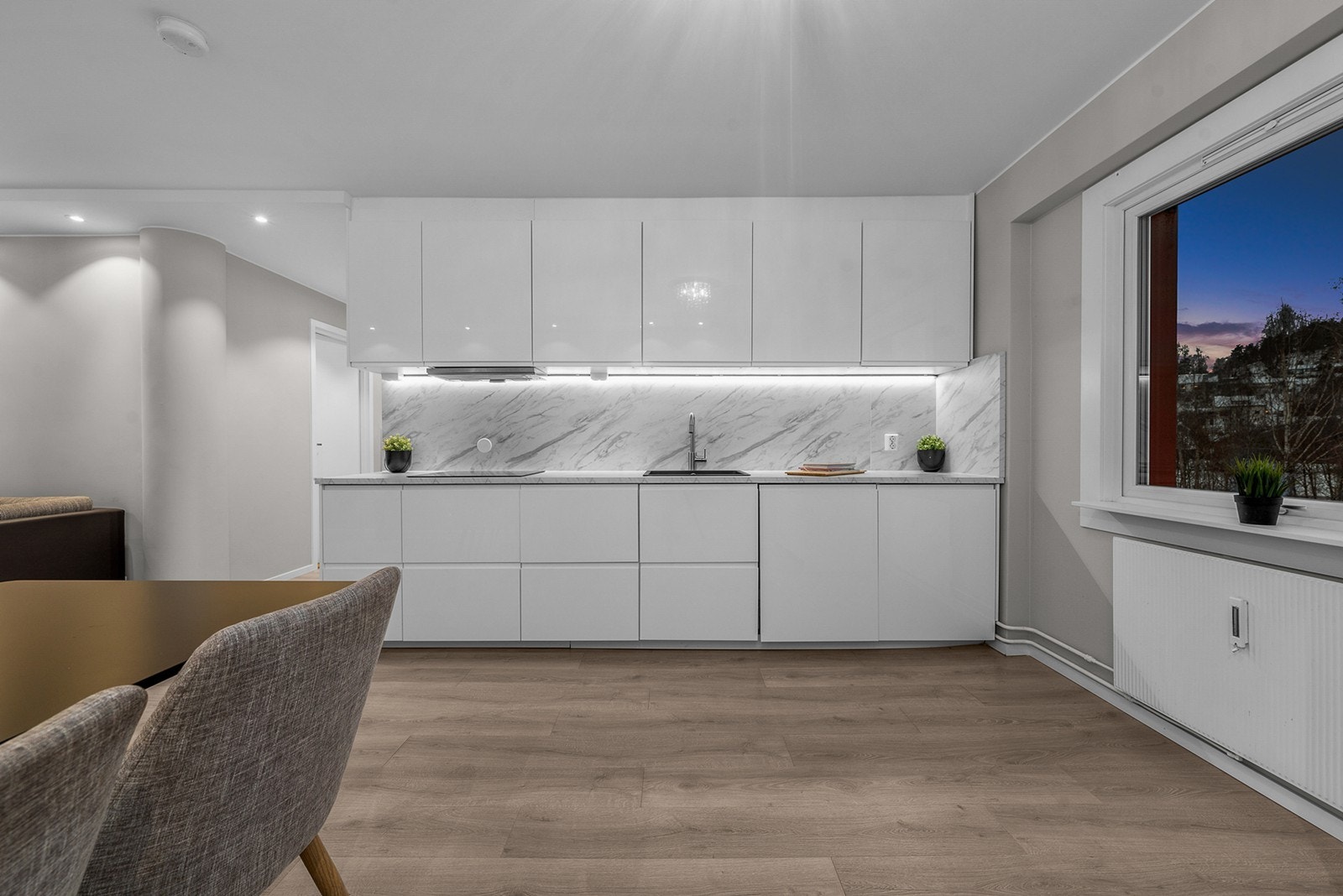 Overskap gir ekstra oppbevaringsplass på kjøkkenet, og benkeplaten av laminat gir en praktisk arbeidsflate Galleribilde