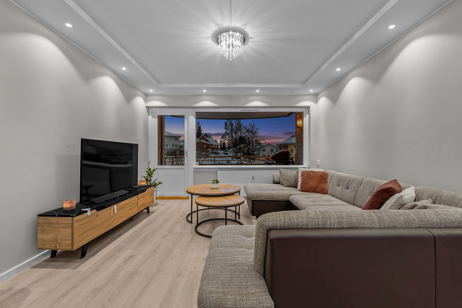 Stuen har malte, slette vegger, laminatgulv og nedforet himling med integrerte downlights som gir et behagelig lysmiljø Galleribilde