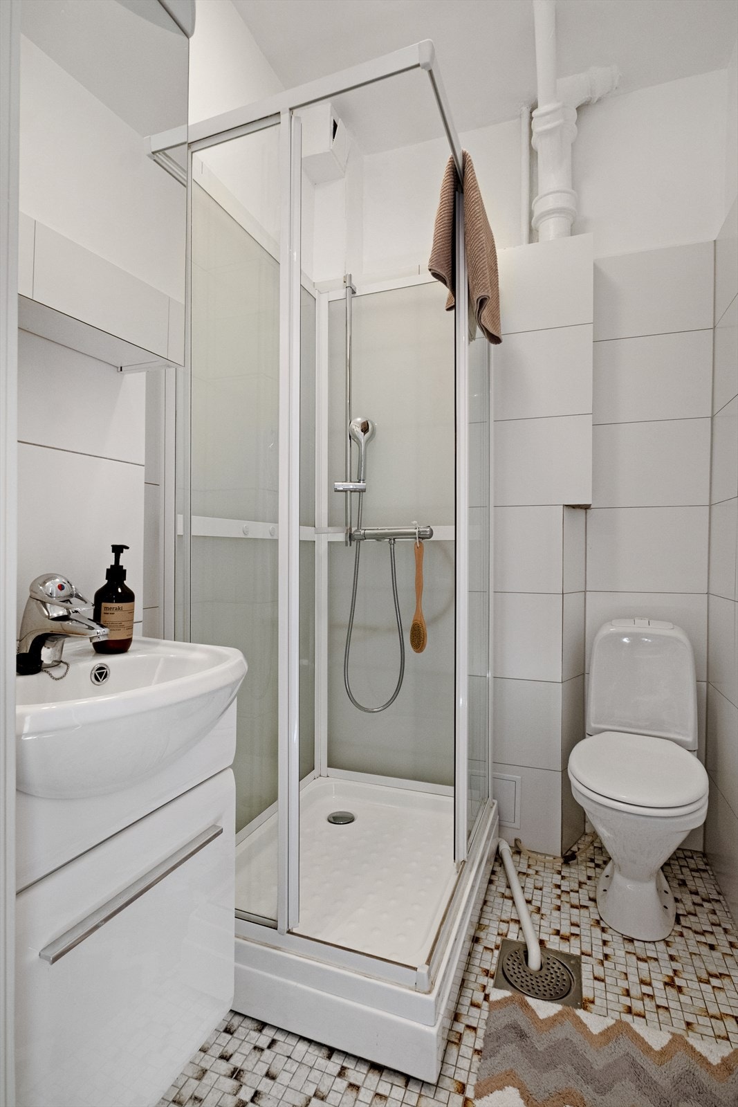 Flislagt bad/wc, avtrekk, speilskap, armatur, lampe, servant med innredning, dusjkabinett, toalett. Galleribilde