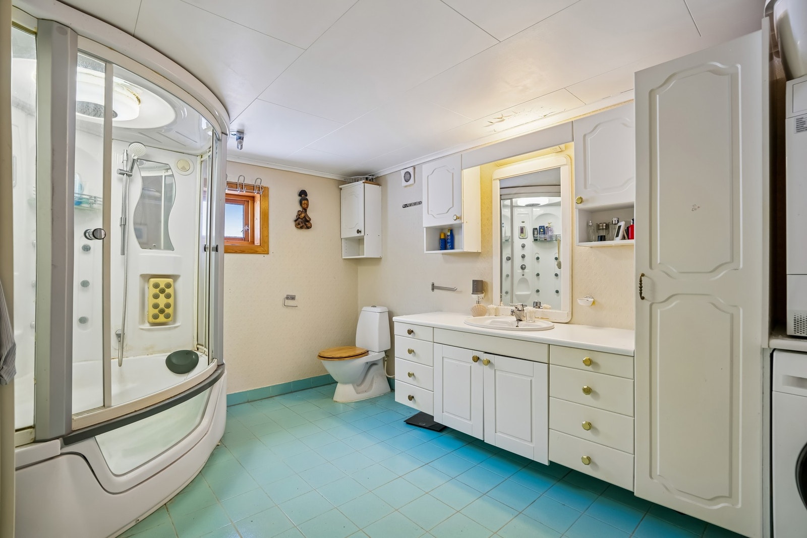 Bad fra 1995 med dusjløsning, servantinnredning og toalett. Flislagt gulv med varmekabler. Galleribilde