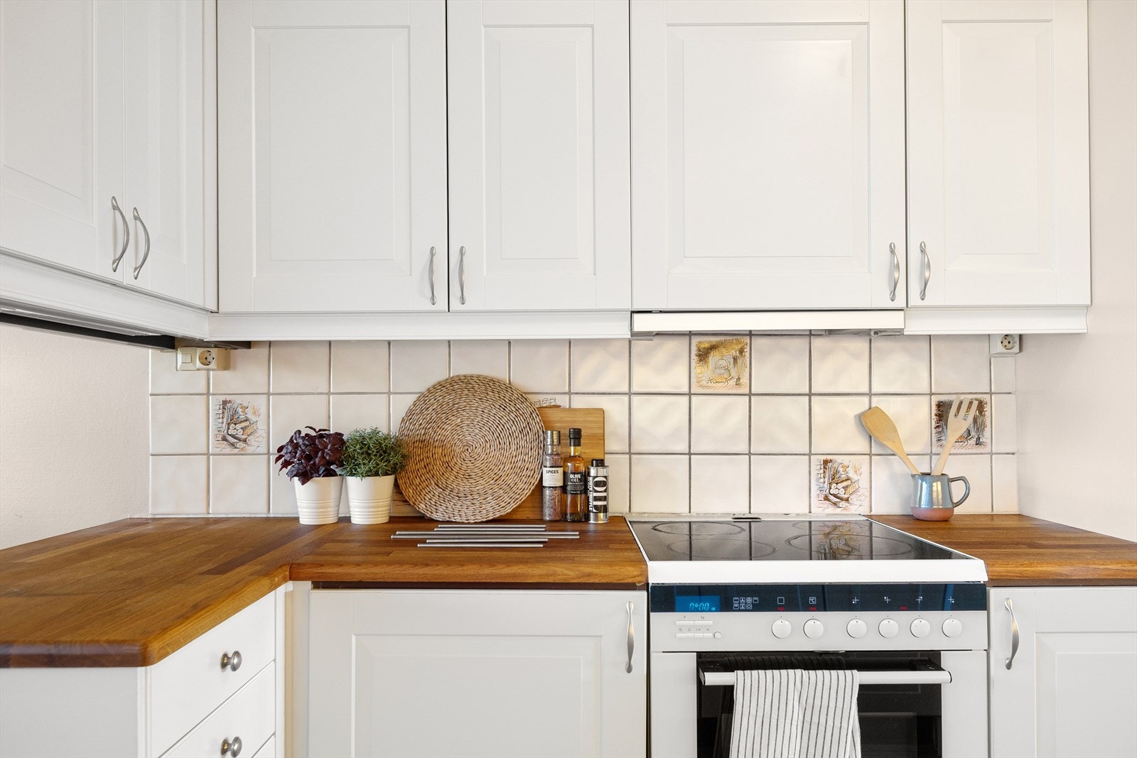 Det er montert fliser på veggene mellom benk og overskap. Galleribilde