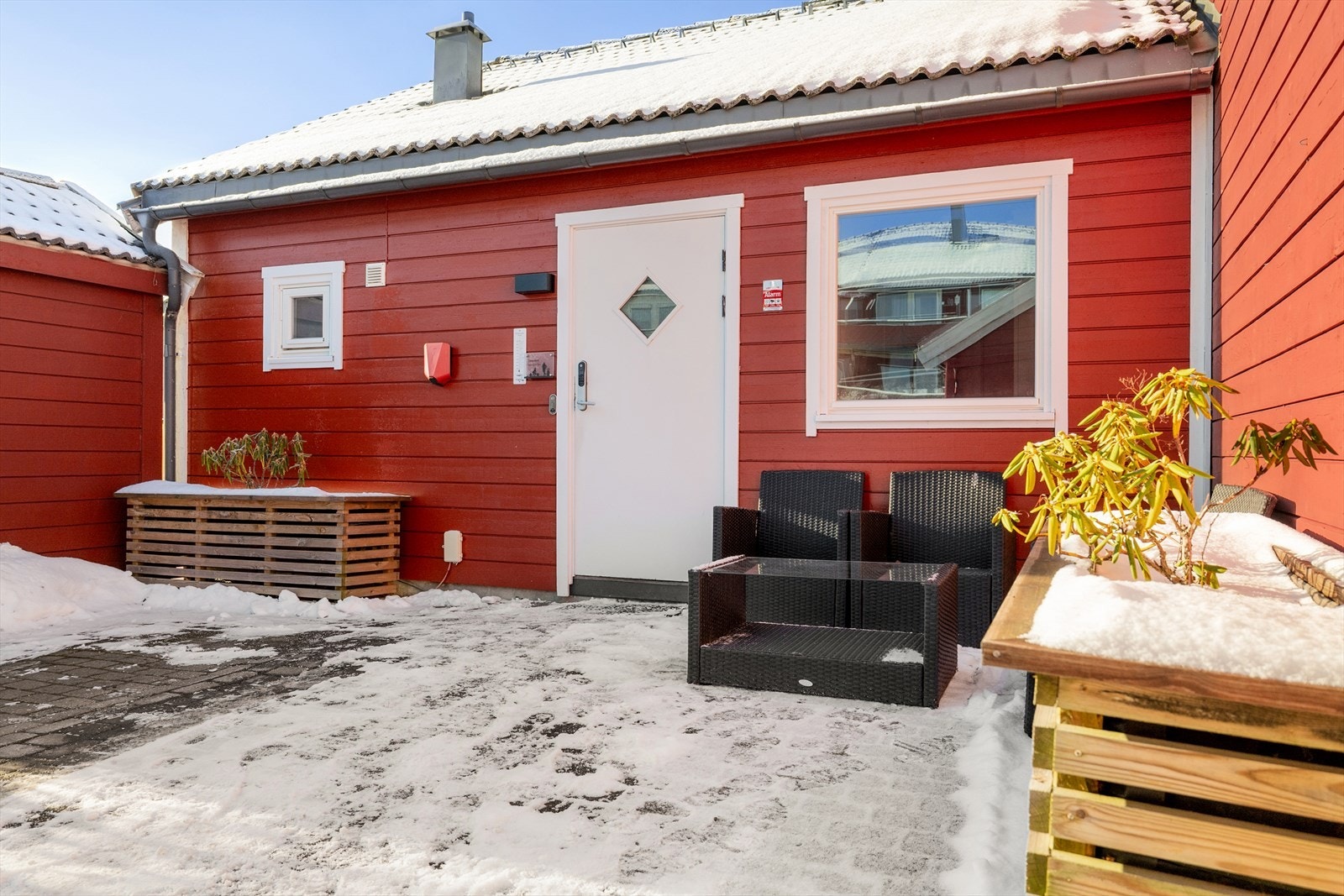 Forsiden av huset har parkeringsplass til en bil med ladeboks montert. Det er også plass til en hyggelig sittegruppe, hvor man har morgensol. Galleribilde