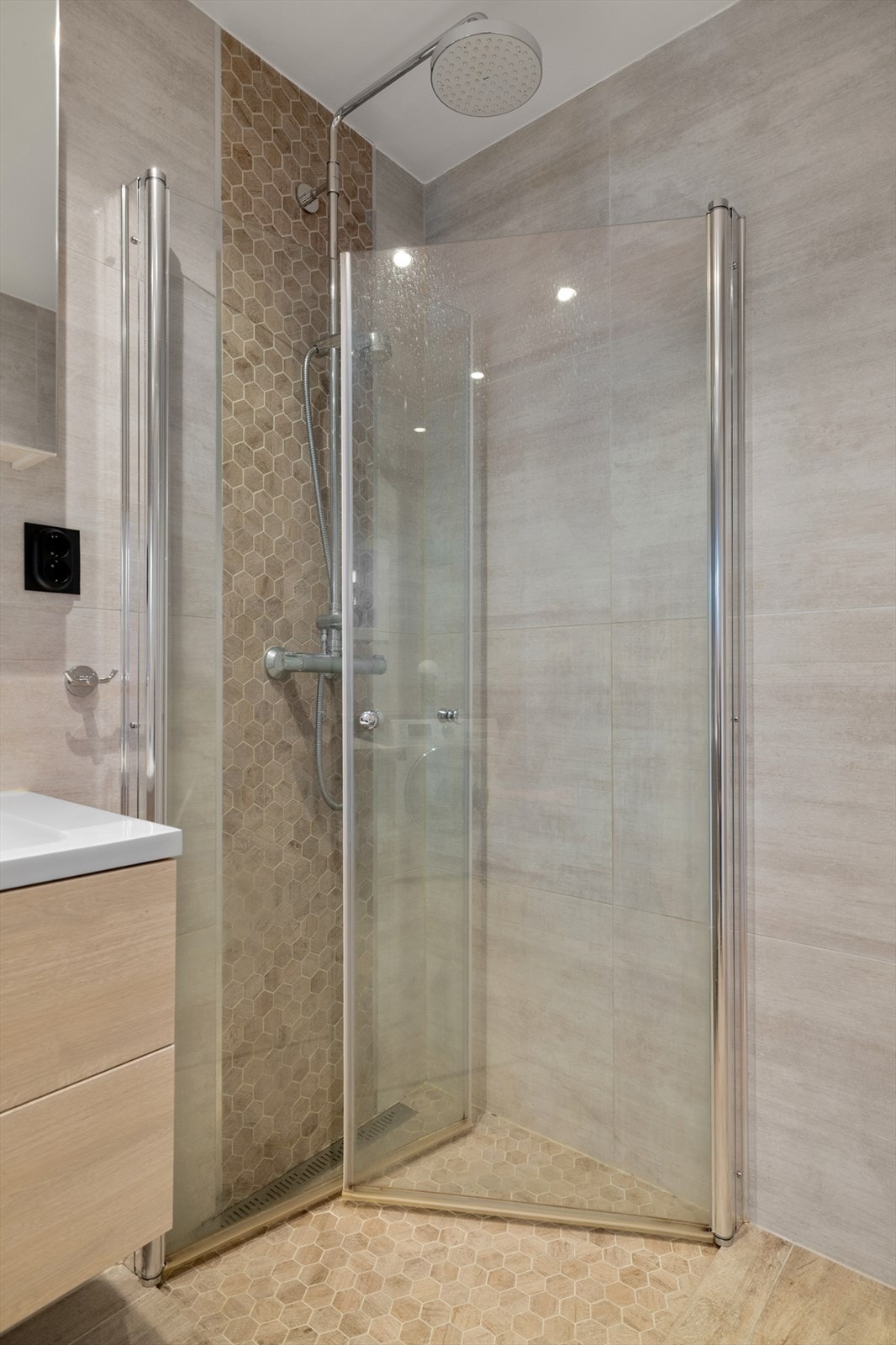 Dusjvegger i herdet glass og mosaikkfliser i dusjsonen gir et stilfullt preg. Galleribilde