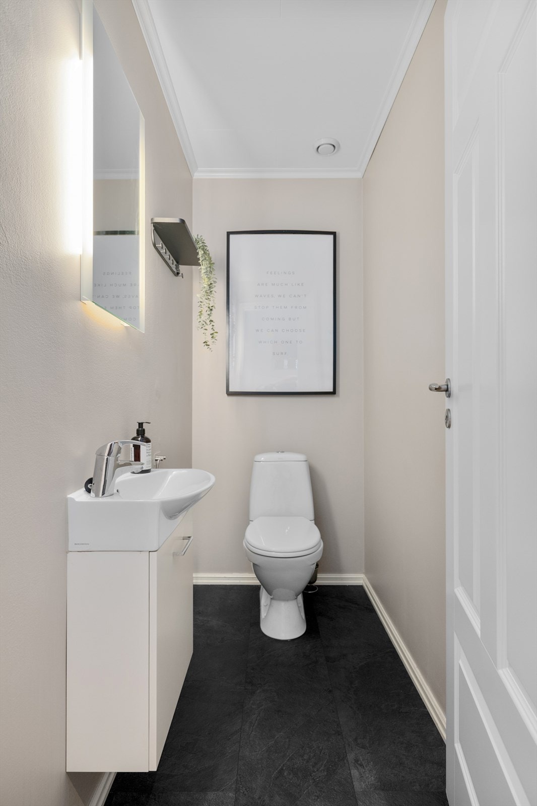 Toalettrommet i underetasjen har laminatfliser på gulvet og vegghengt servantinnredning med LED-belysning. Galleribilde