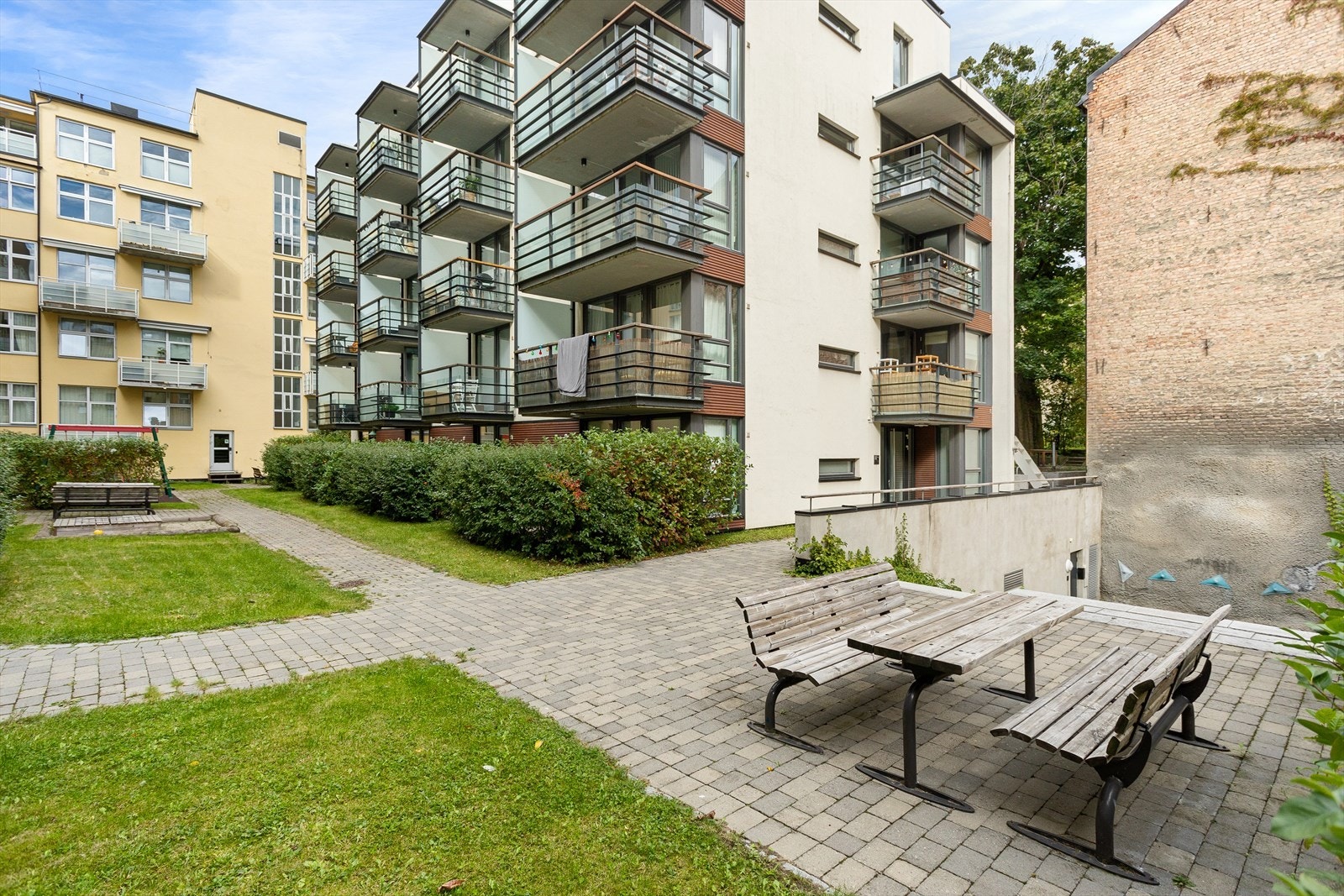 Borettslaget har en frodig bakgård med plen, beplantning og brostein. Det er flere sittegrupper i rolige omgivelser. Galleribilde