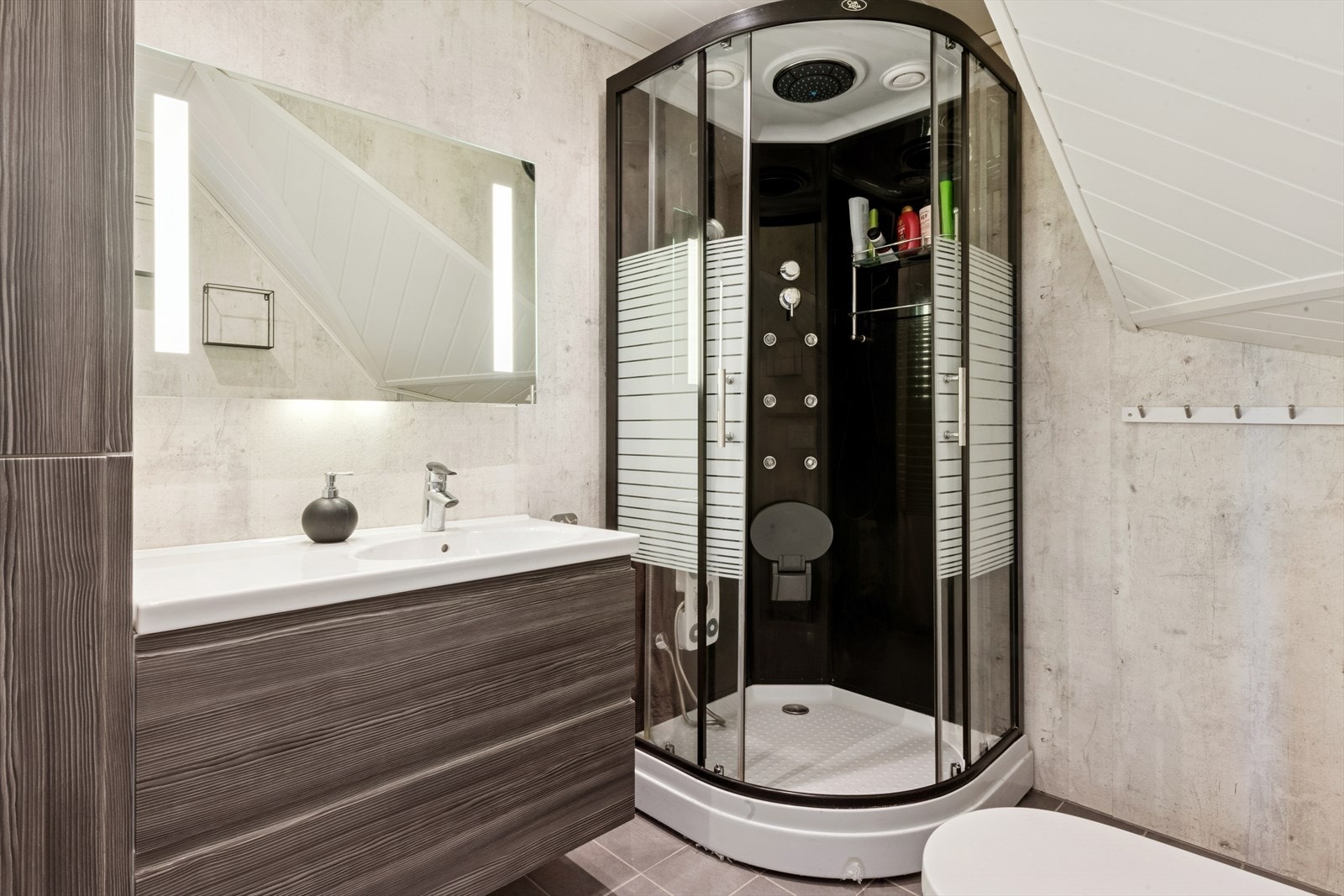 Flott bad med flislagt gulv m/gulvvarme og våtromsplater på vegger. Her finner du vegghengt toalett, dusjkabinett og baderomsinnredning. Galleribilde