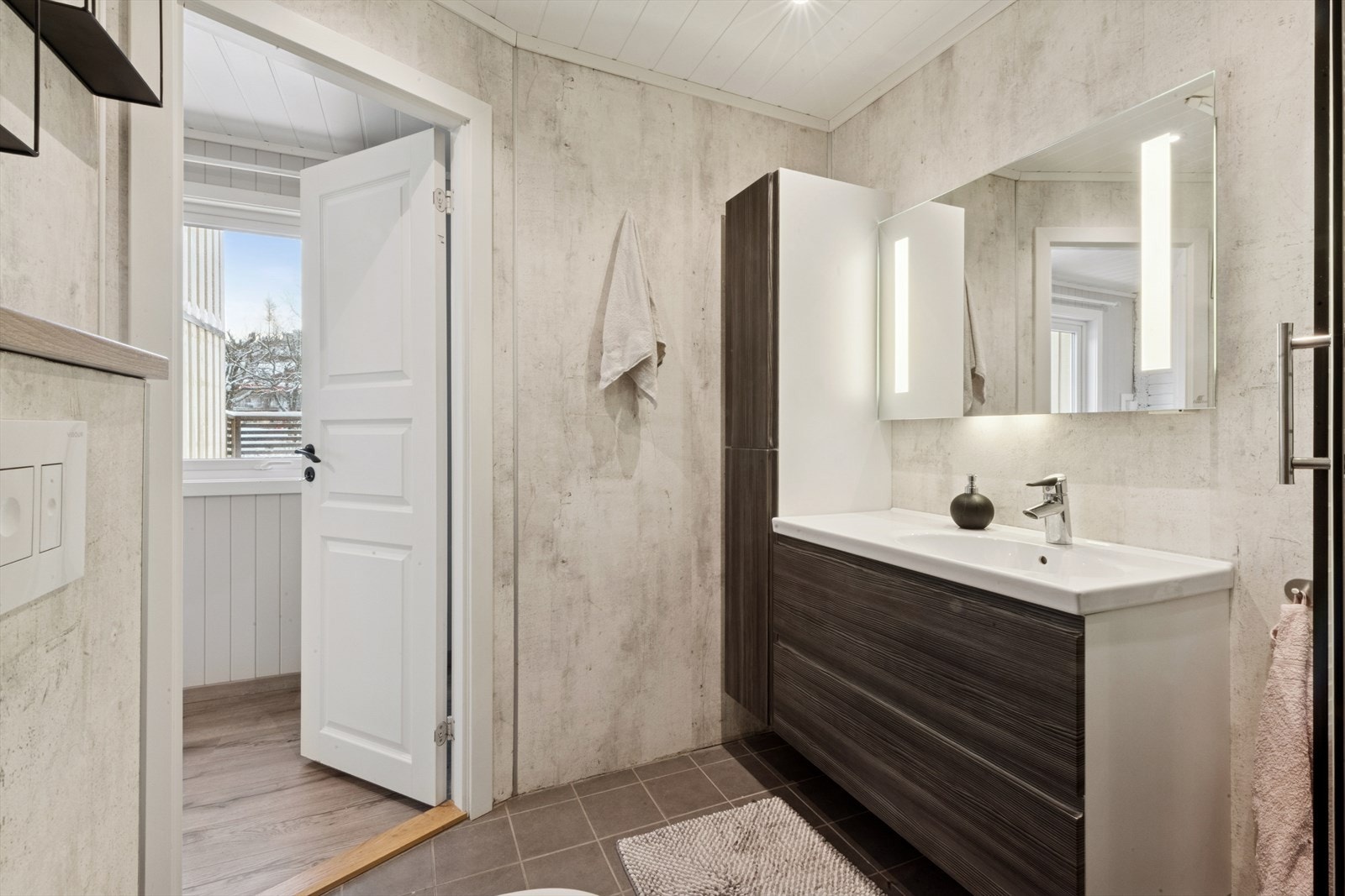 Badet er innredet med en baderomsinnredning m/servant, underskap, høyskap og speil på vegg Galleribilde