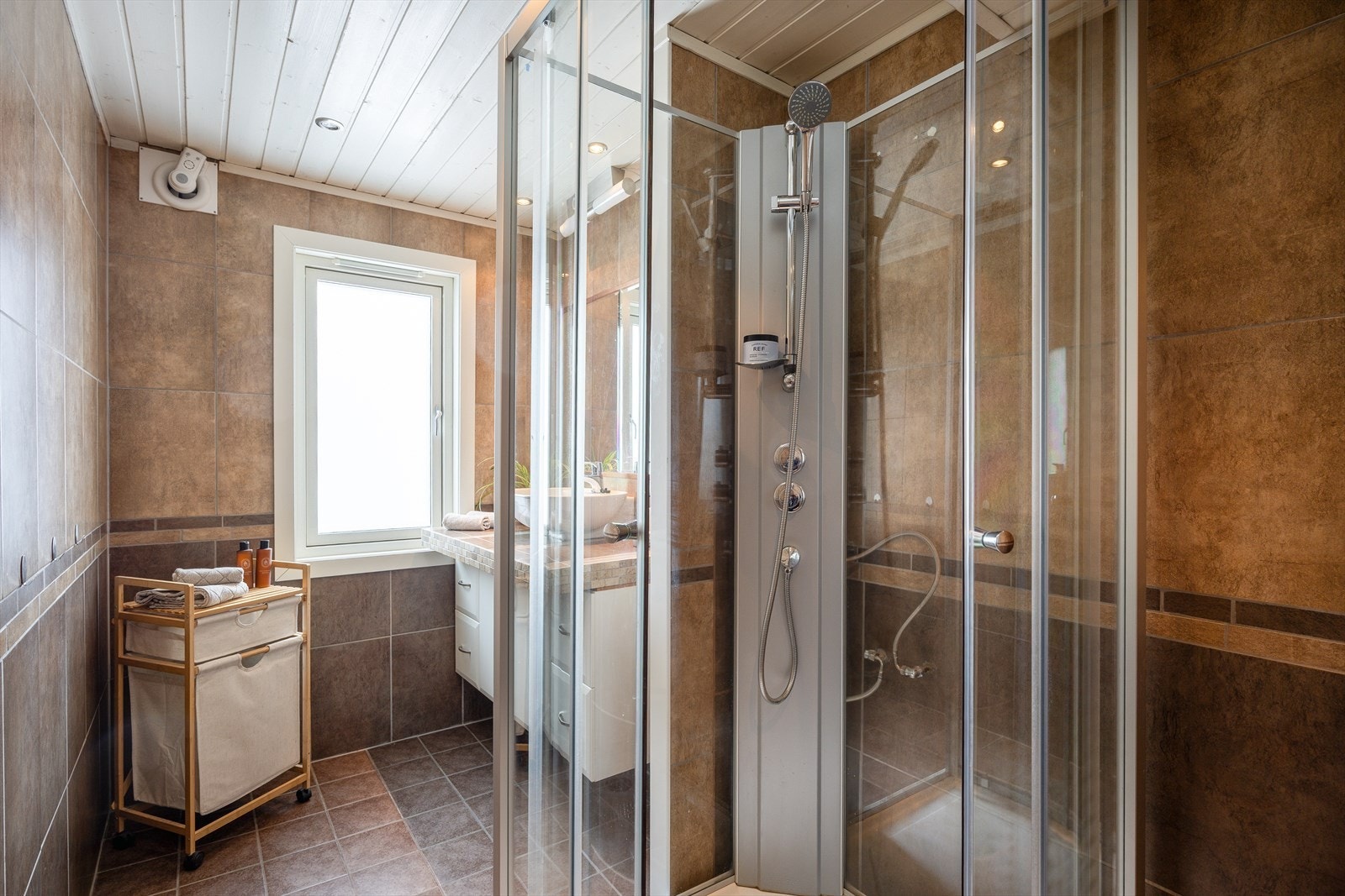 Flislagt bad på 7m². Vaskemaskin er i dag plassert på en av bodene sammen med varmtvannsbereder. Galleribilde