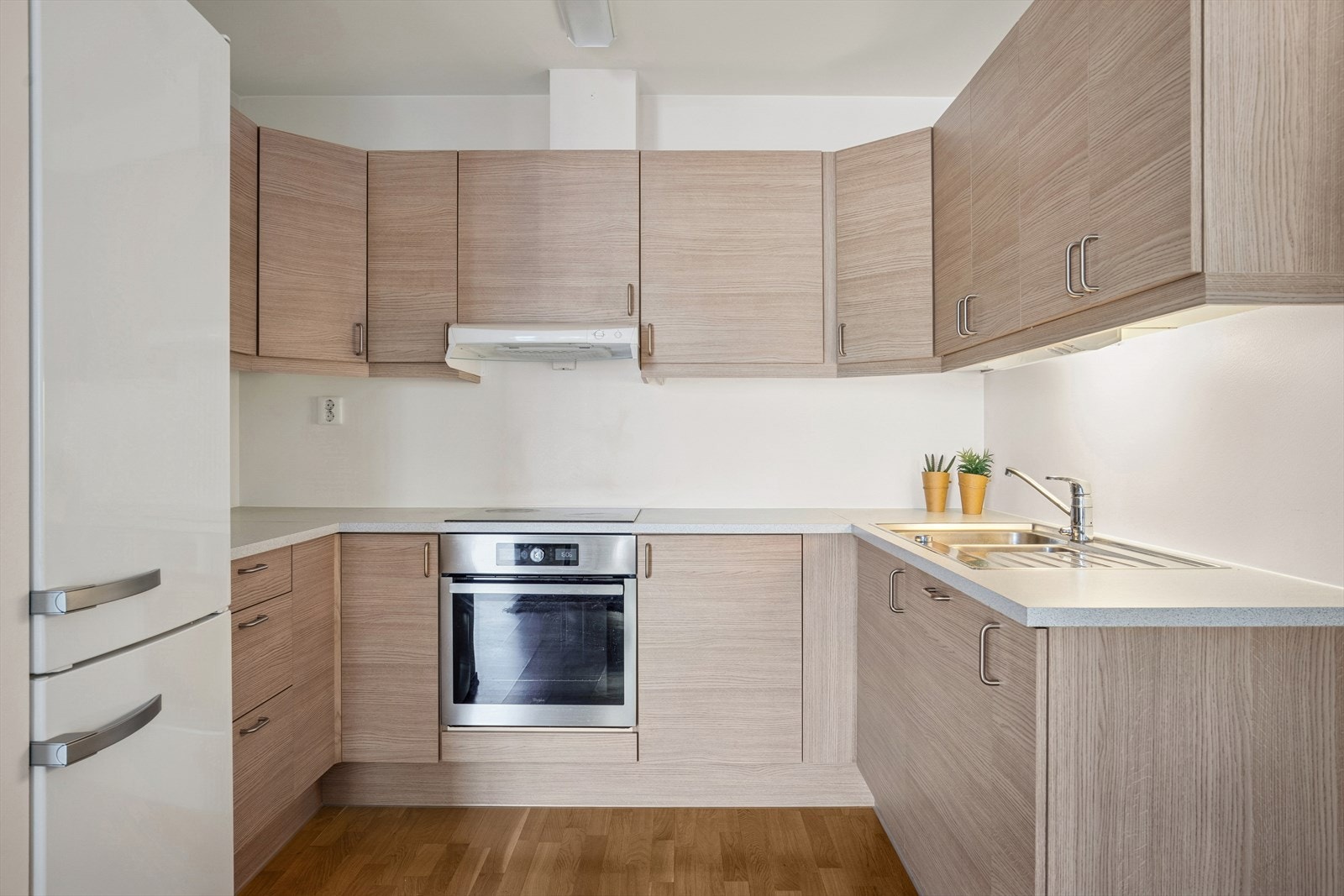 Kjøkkenet har en innredning med glatte fronter og en benkeplate i laminat. Galleribilde