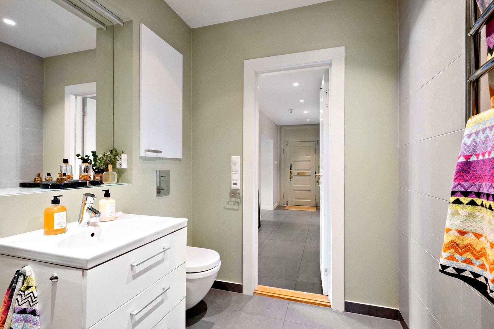 Badet har vegghengt servantinnredning og toalett i tillegg til dusjhjørne og opplegg for vaskemaskin Galleribilde