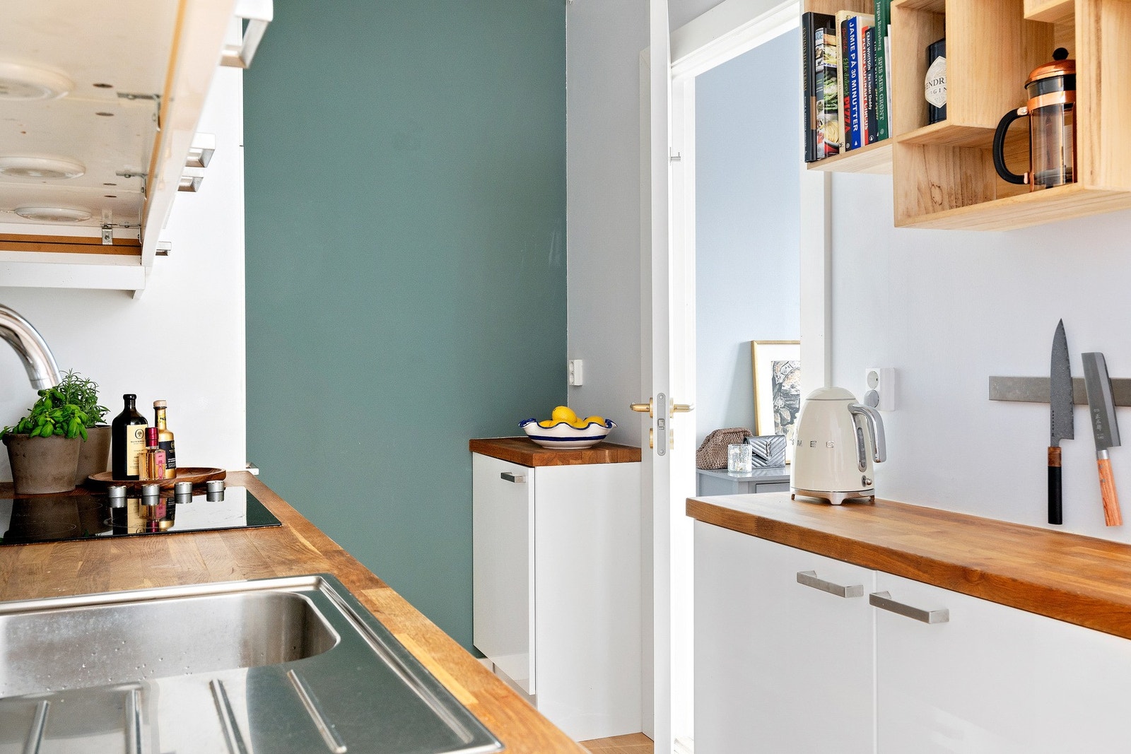 Kjøkkenet har integrerte hvitevarer bestående av keramisk platetopp, stekeovn, oppvaskmaskin, samt kombinert kjøleskap og fryser Galleribilde