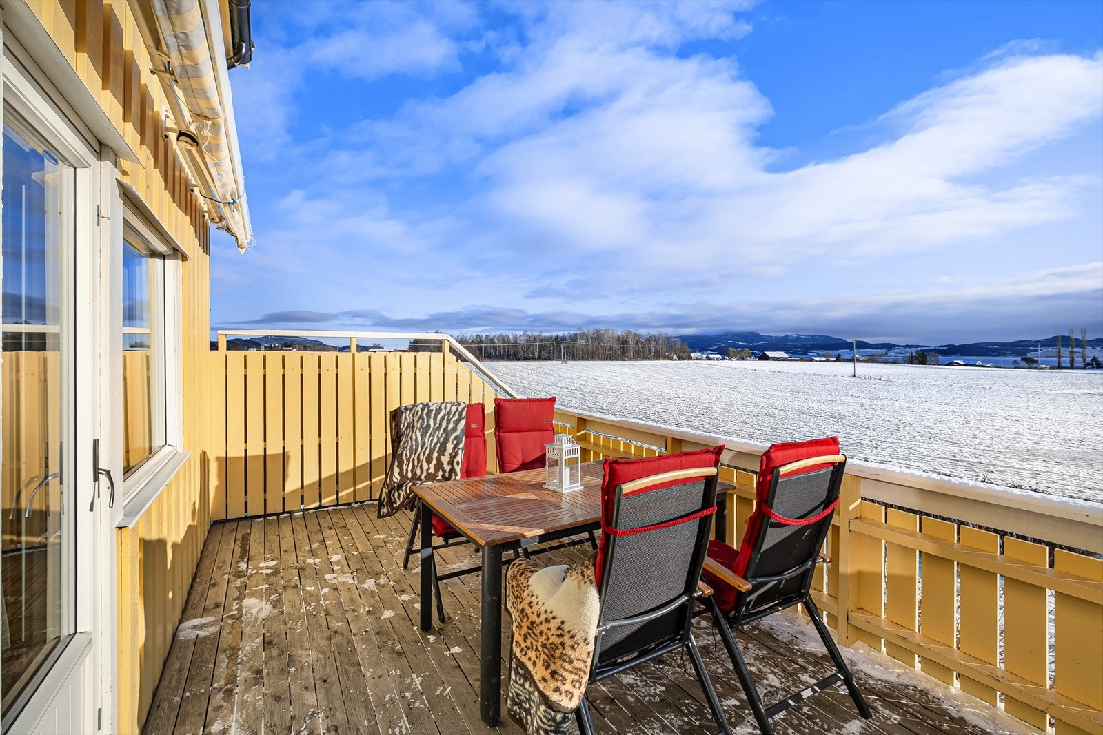 Fra spisestua er det utgang til sydvendt veranda med utsikt mot sjøen og utover landbruksareal Galleribilde