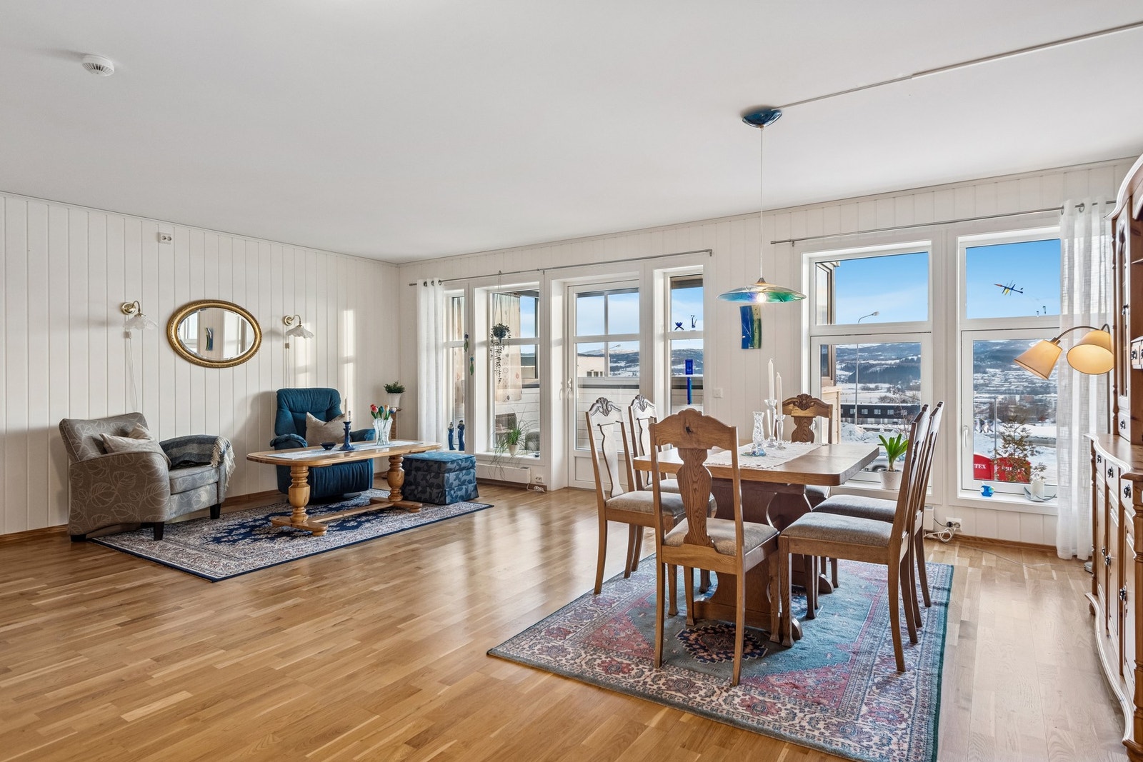 Åpen stue- og kjøkkenløsning med parkett på gulv. Utgang til innglasset balkong. Galleribilde