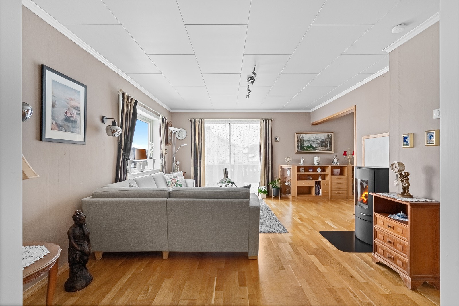 Stuen har en vedovn som skaper varme og stemning, og bidrar til en lun og innbydende atmosfære. Galleribilde