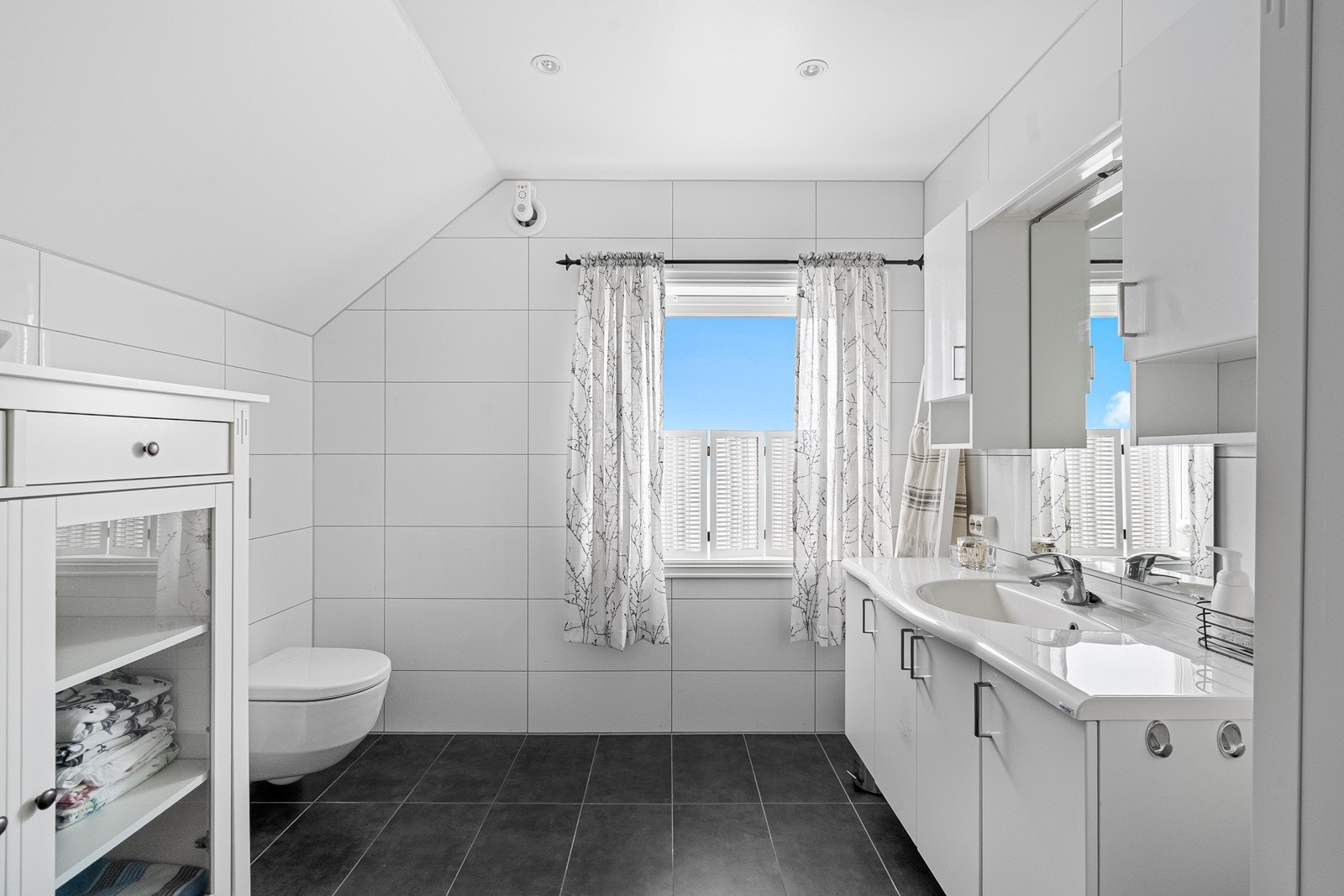 Bad i andre etasje. Badet har baderomsinnredning med slette fronter, servant og speil, i tillegg til vegghengte skap for god oppbevaring. Det er vegghengt toalett og dusj med dobbel dør og dusjvegg. Galleribilde