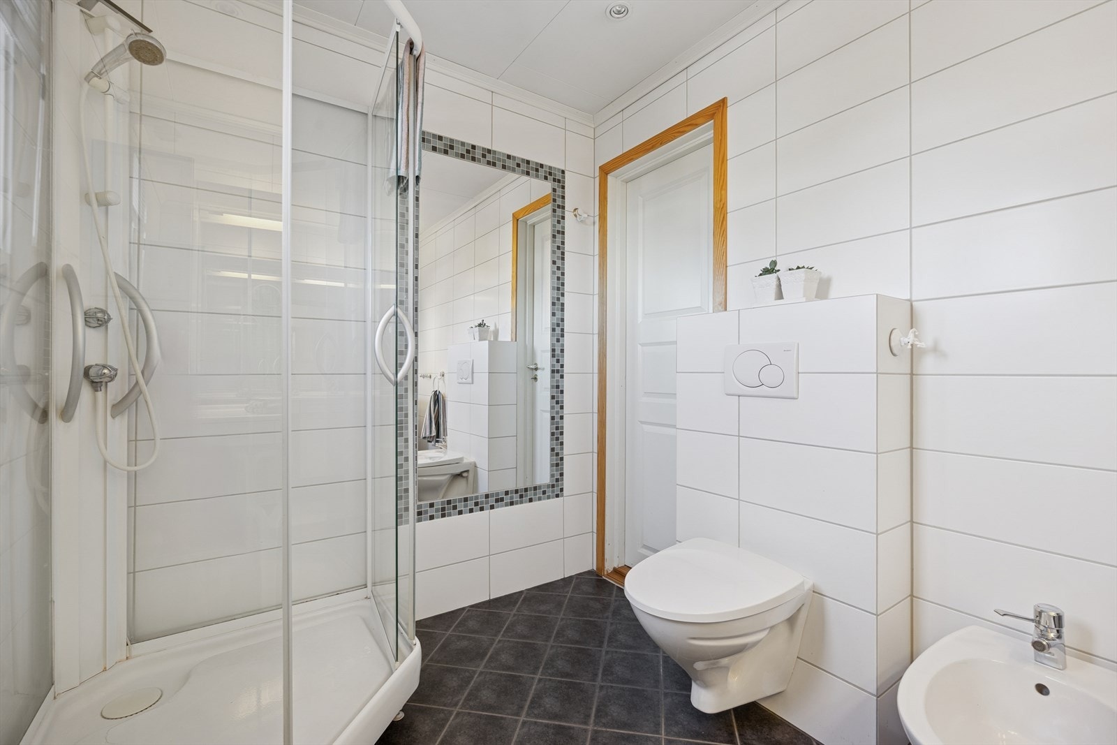 Badet er flislagt på både vegger og gulv, med behagelig gulvvarme. Galleribilde