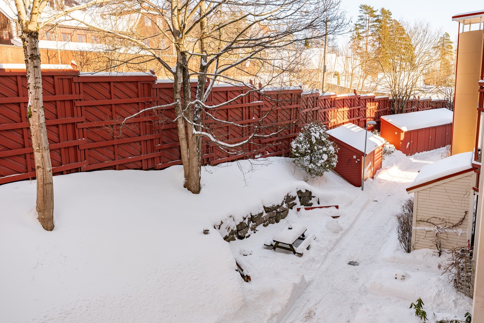 Fellestomt som er opparbeidet med gressplen, beplantning, sittegrupper og lekeområder. Galleribilde