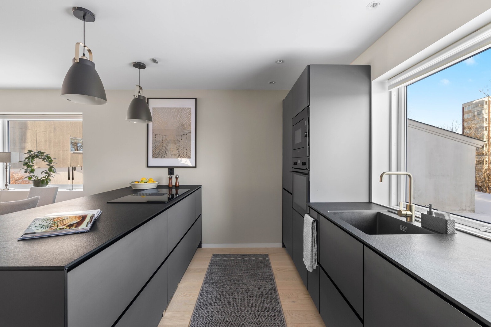 Stilrent og moderne kjøkken med slette fronter og god skapplass. Romslig benkeplass og integrerte hvitevarer gir et funksjonelt arbeidsområde. Galleribilde