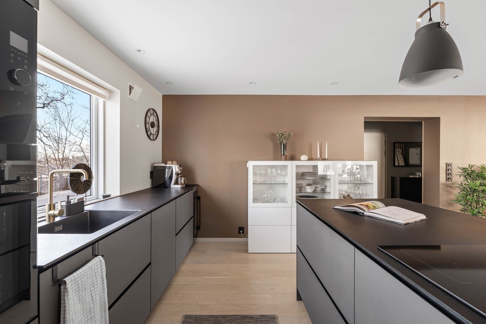 Integrerte hvitevarer, vinskap og ventilator integrert i platetopp gir et ryddig og gjennomført preg. Galleribilde