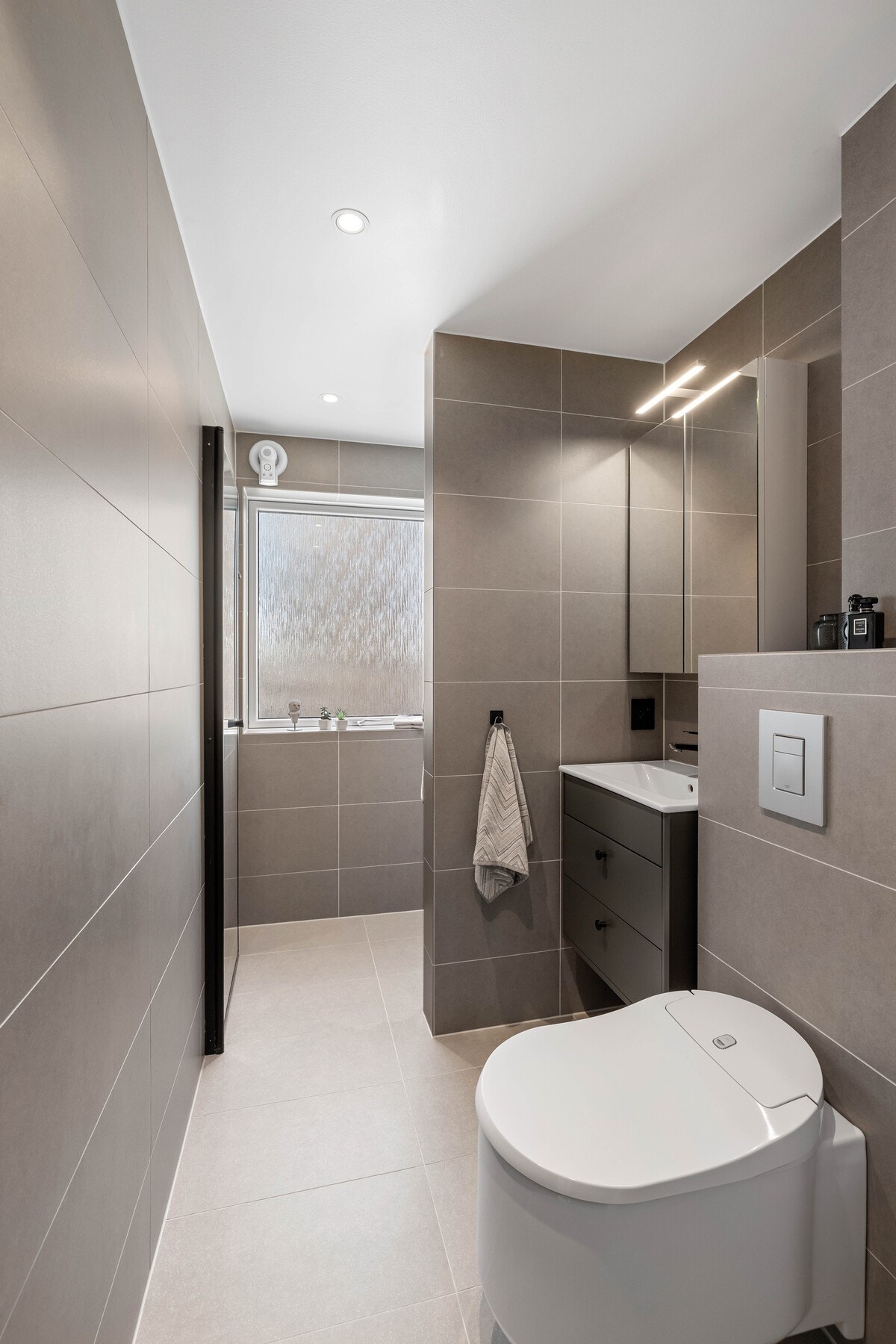 Moderne bad med tidsriktige materialvalg. Praktisk innredning med god oppbevaringsplass. Galleribilde