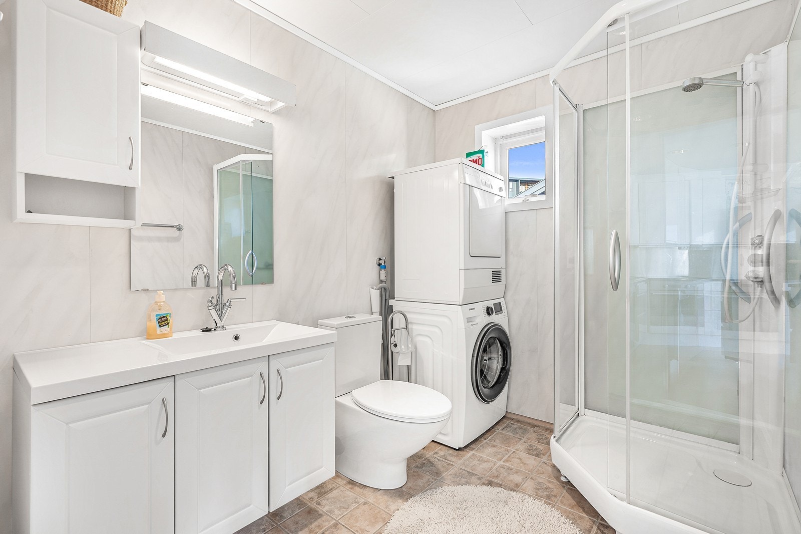 Badet er innredet med toalett, dusjkabinett og vask med oppbevaring. Det er også tilrettelagt for vaskemaskin. Galleribilde