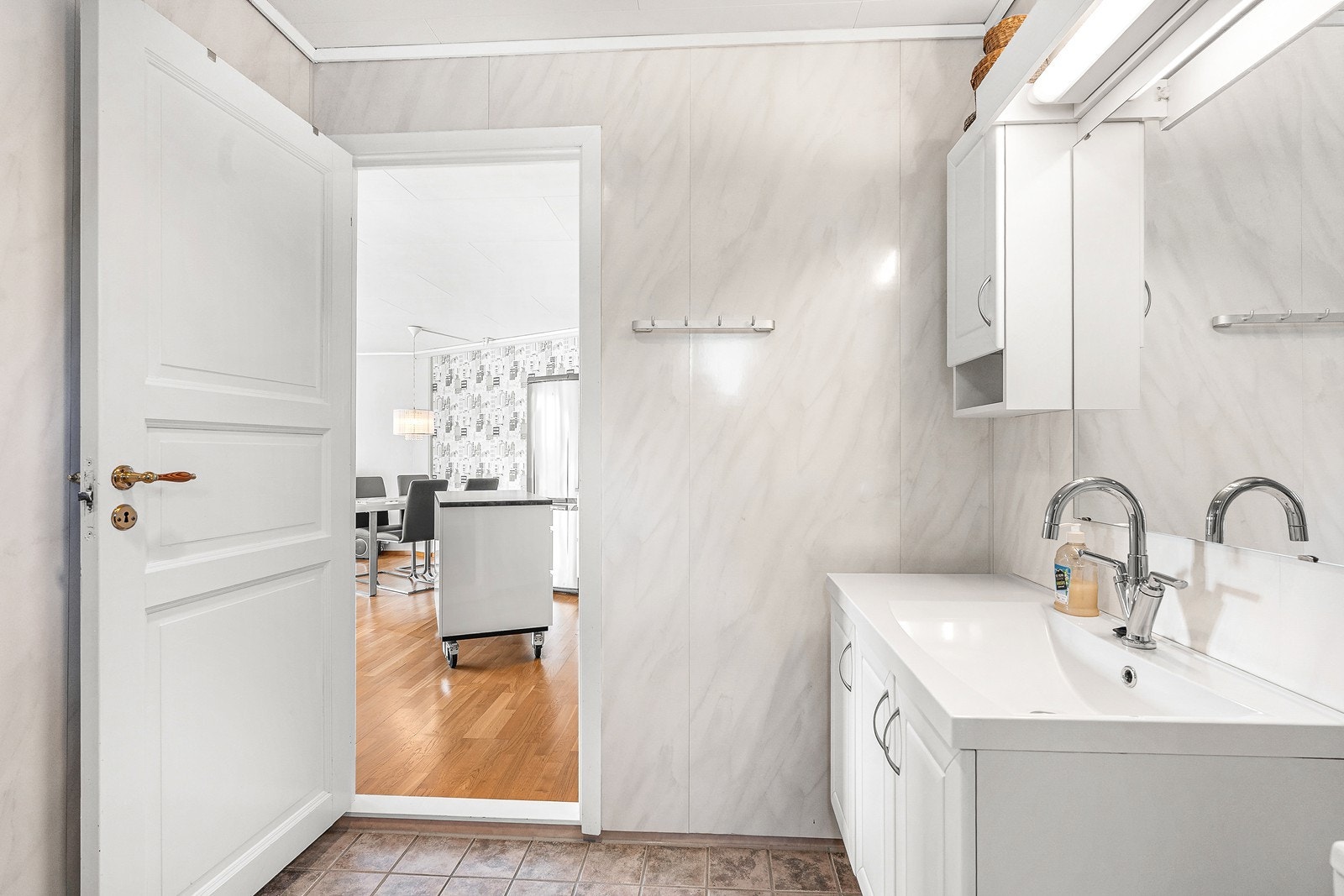 Badet har overflater fra byggeår med baderomsplater på vegger og fliser på gulv. Galleribilde