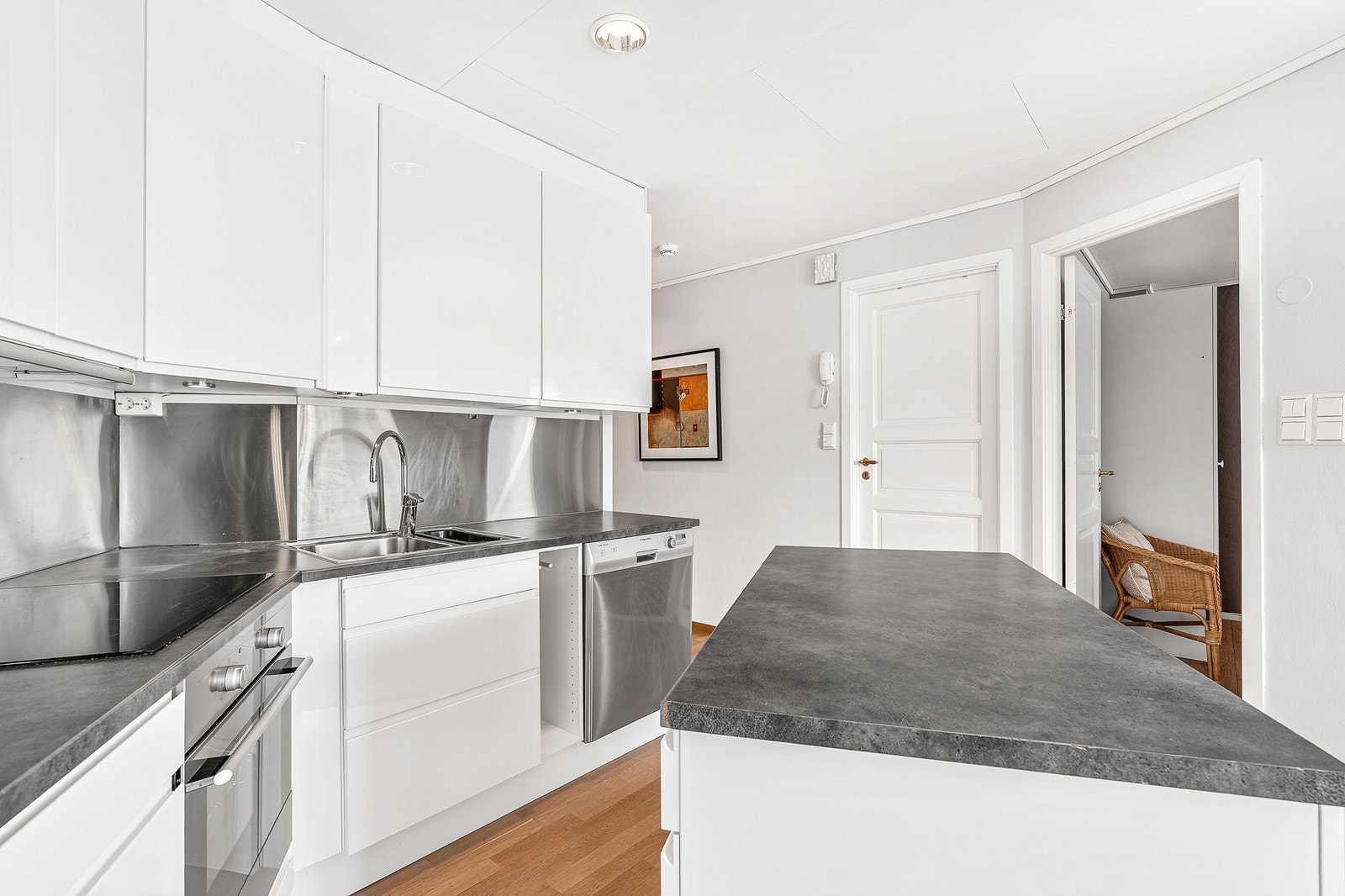 Kjøkkenet er innredet med hvite fronter og laminat benkeplate. Galleribilde