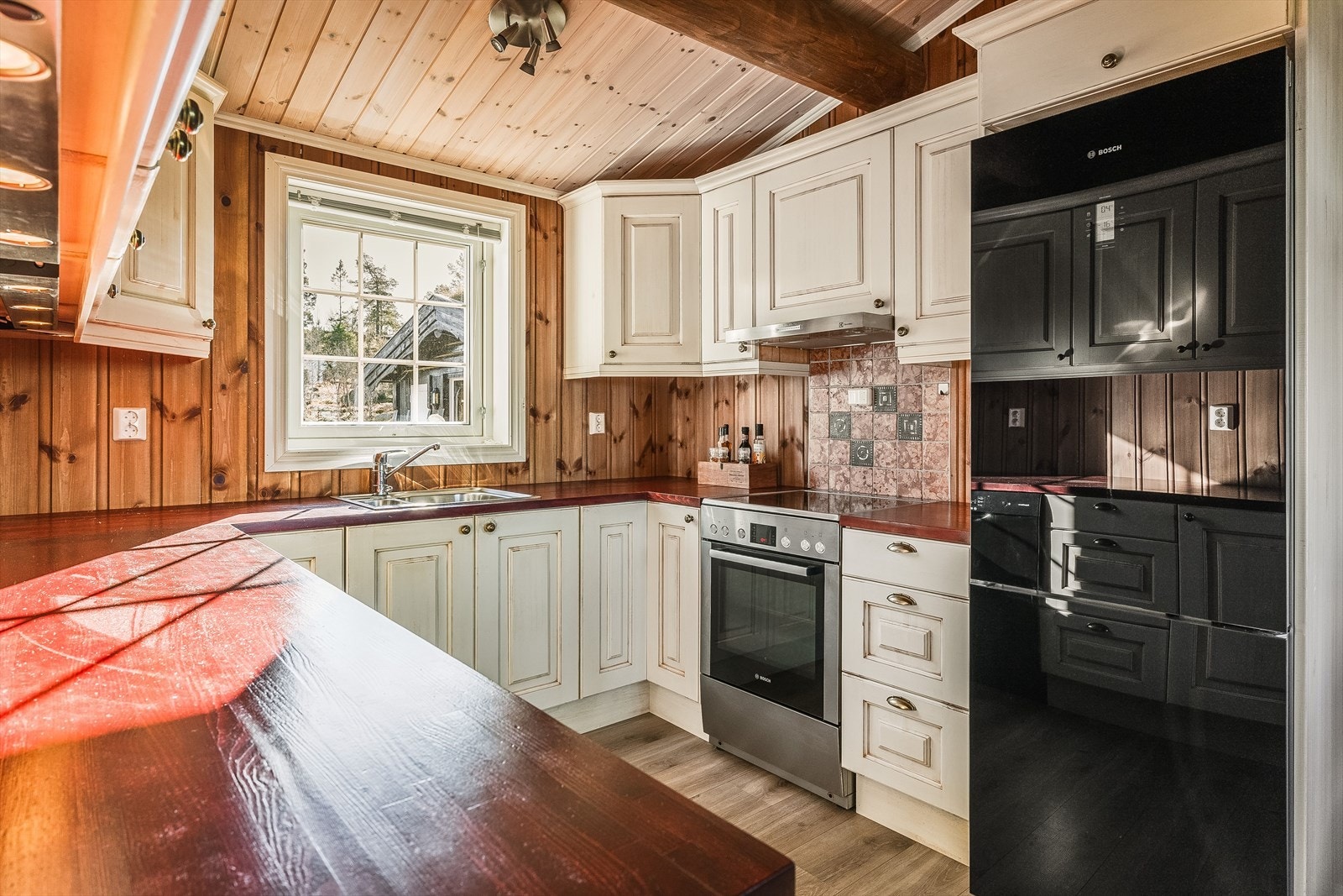 Et velfungerende og fint kjøkken med gode arbeidsflater. God belysning under overskap i tillegg til et stort vindu som slipper inn naturlig lys. Galleribilde