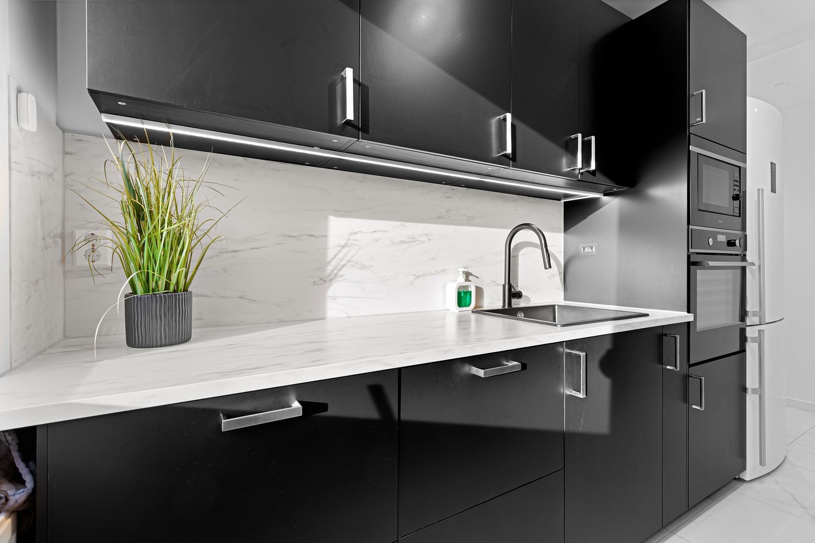 Rommet har moderne fliser i hvitgrå tone, glatte vegger og god belysning i fire soner Galleribilde