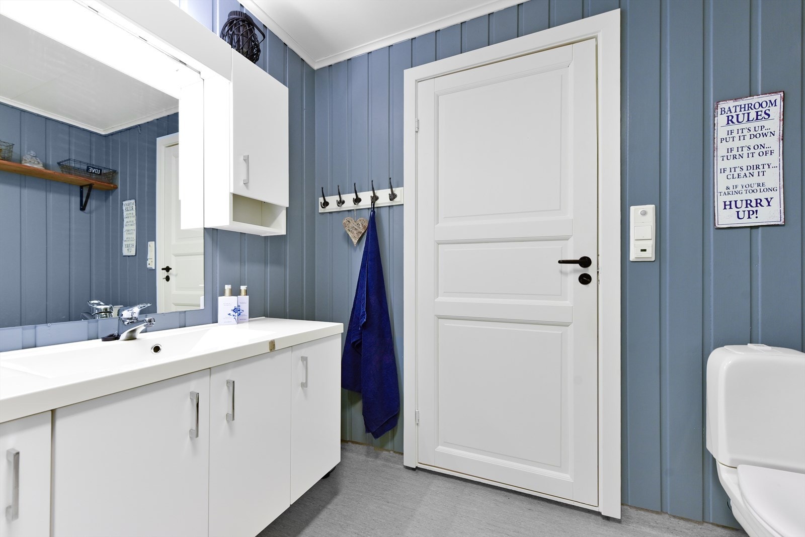 Eget bad i underetasjen som er utstyrt med servant med underskap, toalett og dusj Galleribilde