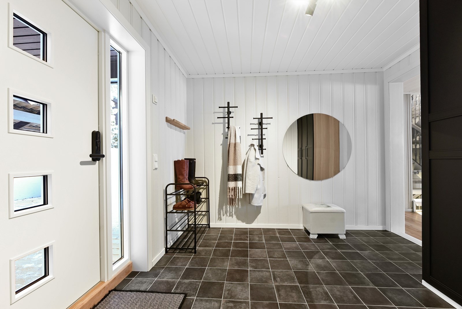 Velkommen inn i en lys og romslig entré med flislagt gulv med varmekabler Galleribilde