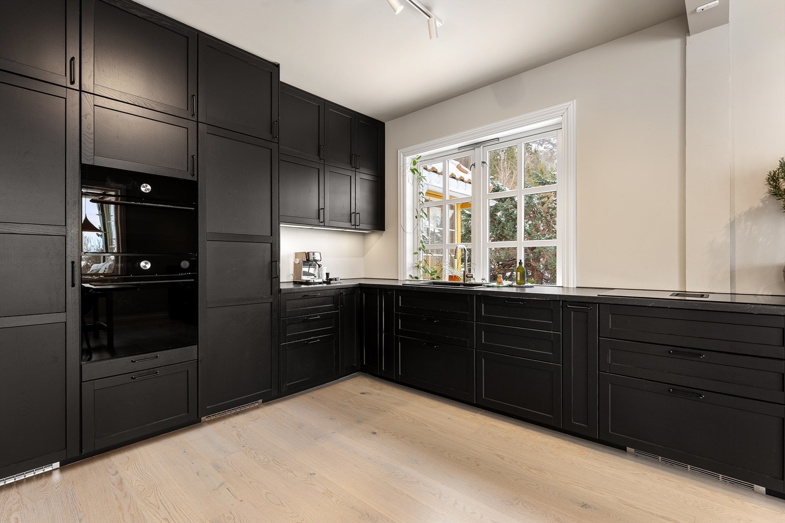 Kjøkkenet er romslig og praktisk utformet langs to vegger, med store arbeidsflater og mye oppbevaringsplass. Galleribilde