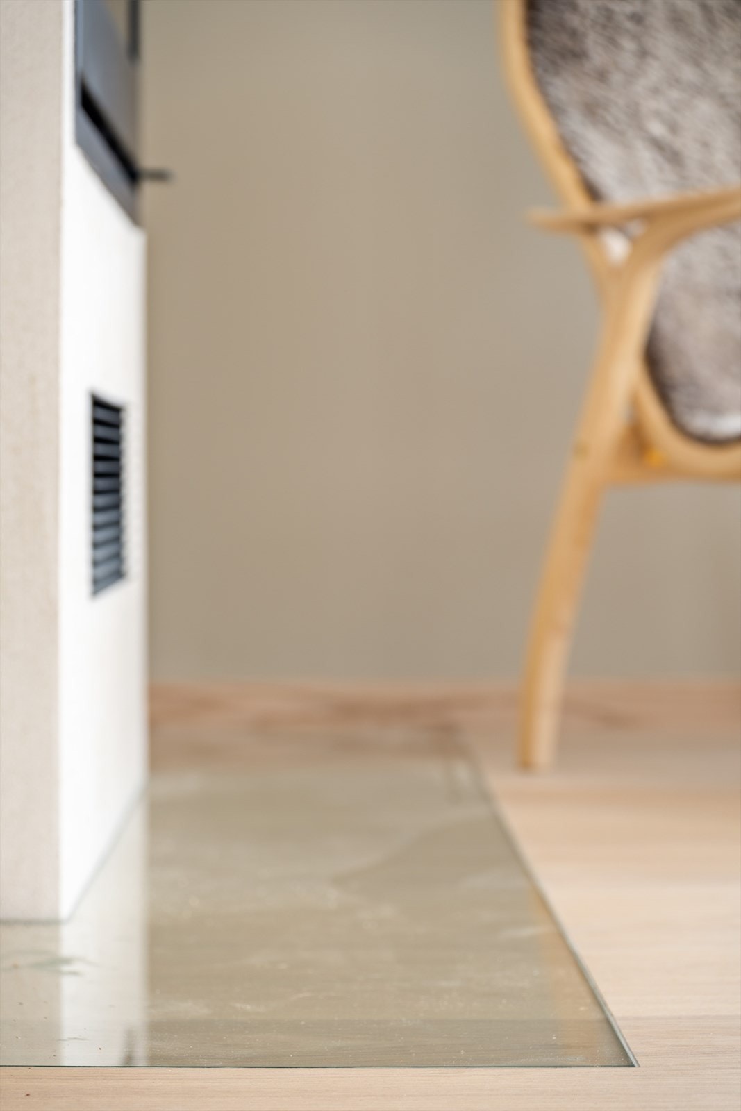 Stilig detalj, med nedfelt glassplate foran peisovn, som går i flukt med parketten Galleribilde