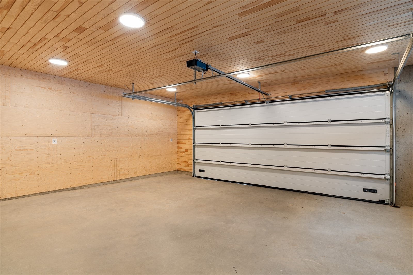 Garasje med heltre kvistfri furu i himling, finerplater på vegg og stålglattet betong gulv Galleribilde