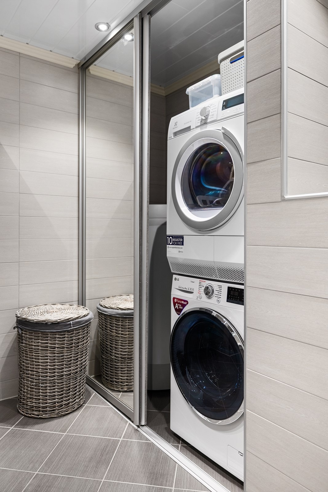 Fin løsning med tørketrommel og vaskemaskin bak skyvedører Galleribilde